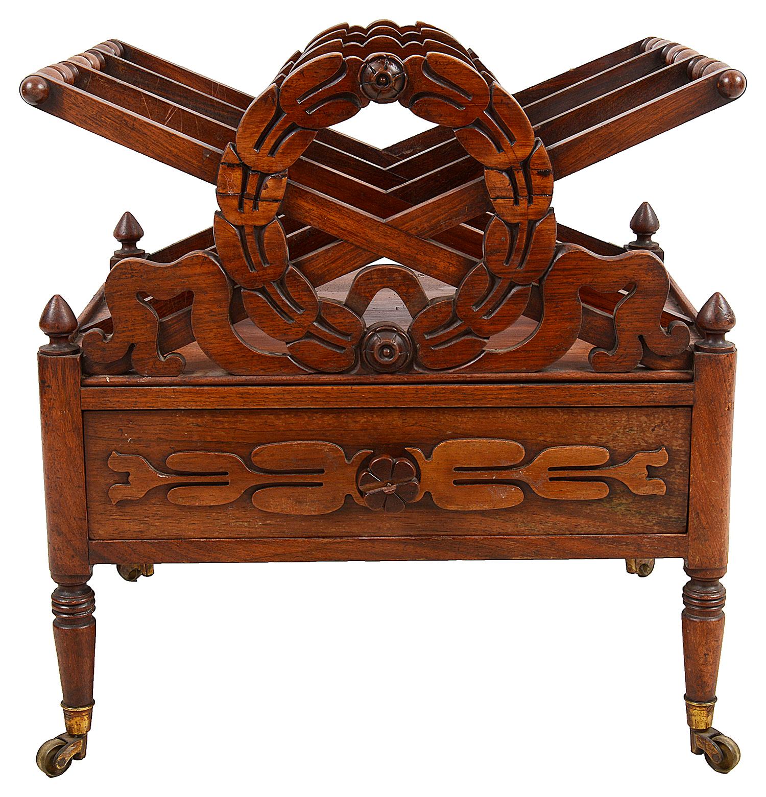 A very good quality late Regency period Goncalo Alves Music Canterbury, having carved wreath decoration, X-frame divisions, a single mahogany lined frieze drawer, raised on turned tapering legs, terminating in the original brass castors.