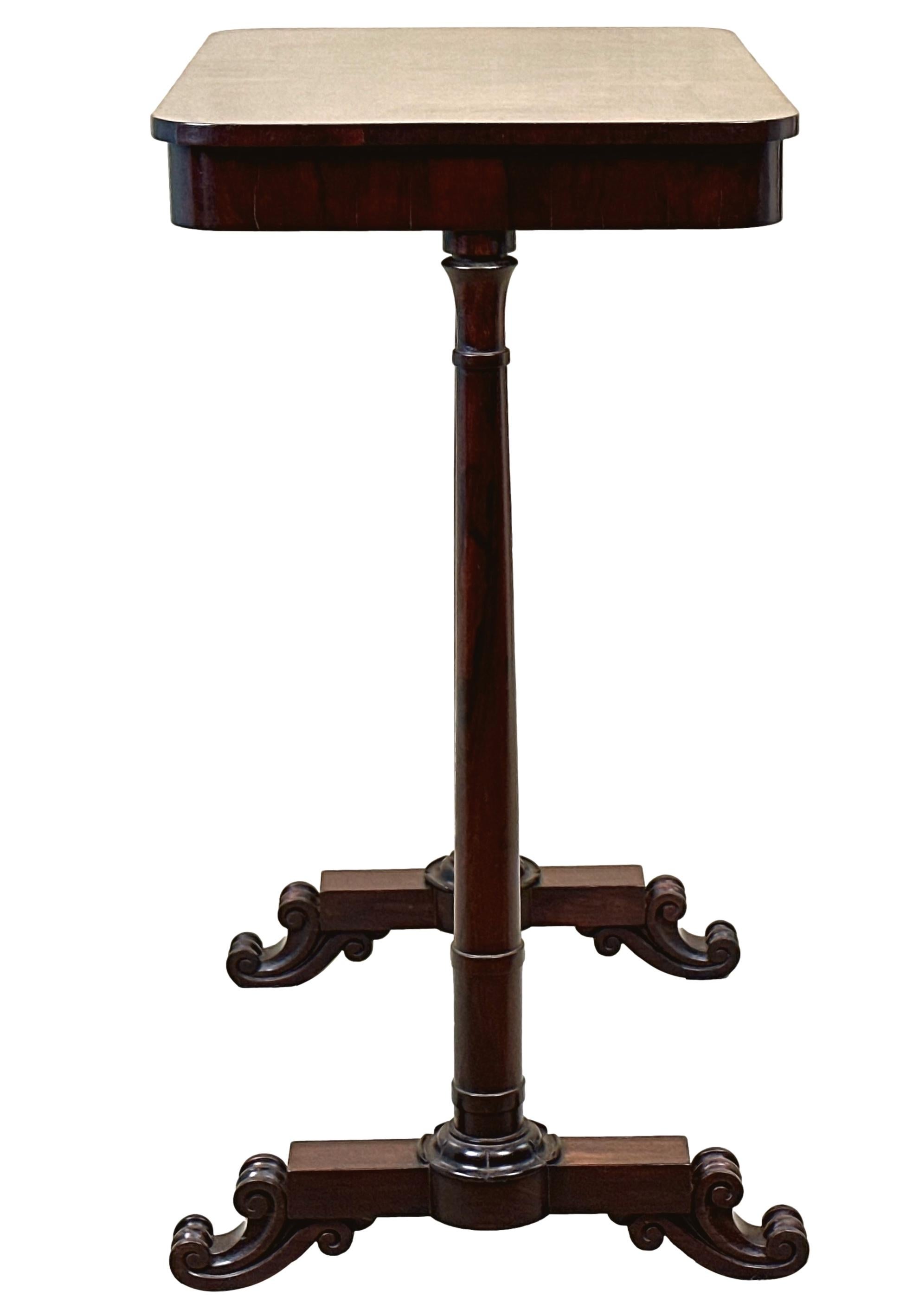 A Good Quality, 19th Century, Late Regency Period Rosewood Occasional Lamp Table Of Diminutive Proportions, Having Well Figured Rectangular Top Raised On Elegant Turned End Supports, With Attractive Stylised Carved Lotus Leaf Decoration And Carved