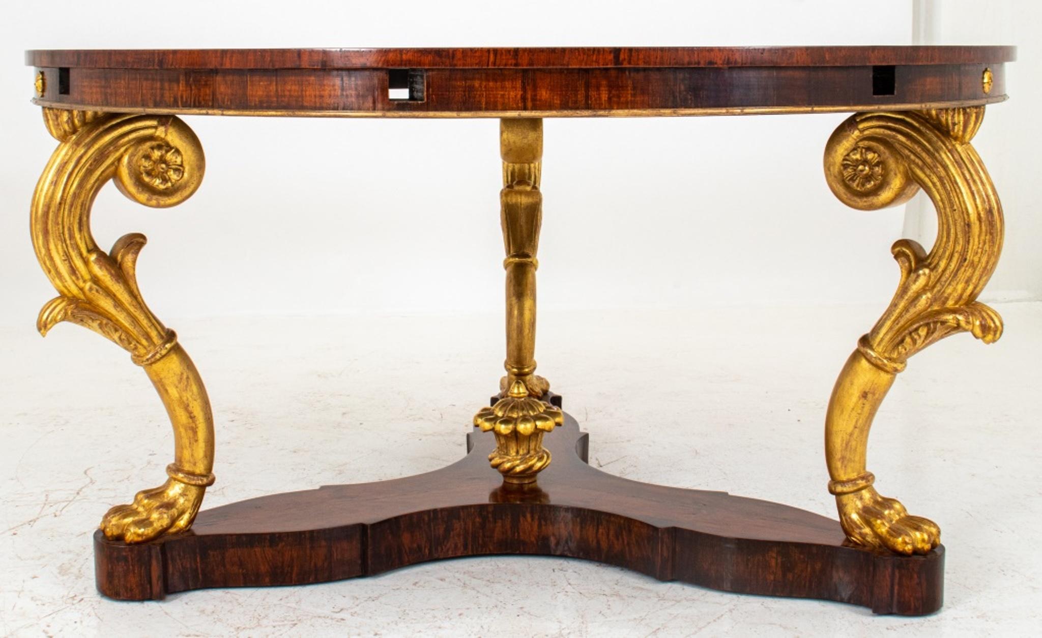 Late Regency style parcel-gilt jacaranda wood expanding dining table, with circular top above an apron fitted with apertures for quarter-round leaves, the whole on three gilded scrolling volute form legs on a tripartite concave platform base