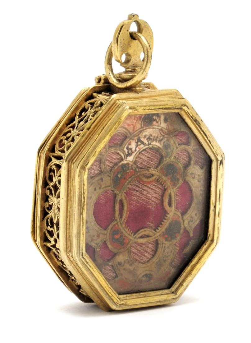 OCTAGONAL RELIQUARY PENDANT
Probably Italy, c. 1600
Fire-gilded brass, glass, velvet, ink on paper
Weight 63.2 grams; dimensions 82 × 47 × 21 mm (with loop)

Physical description: Double-sided pendant in octagonal form made of fire-gilded brass.