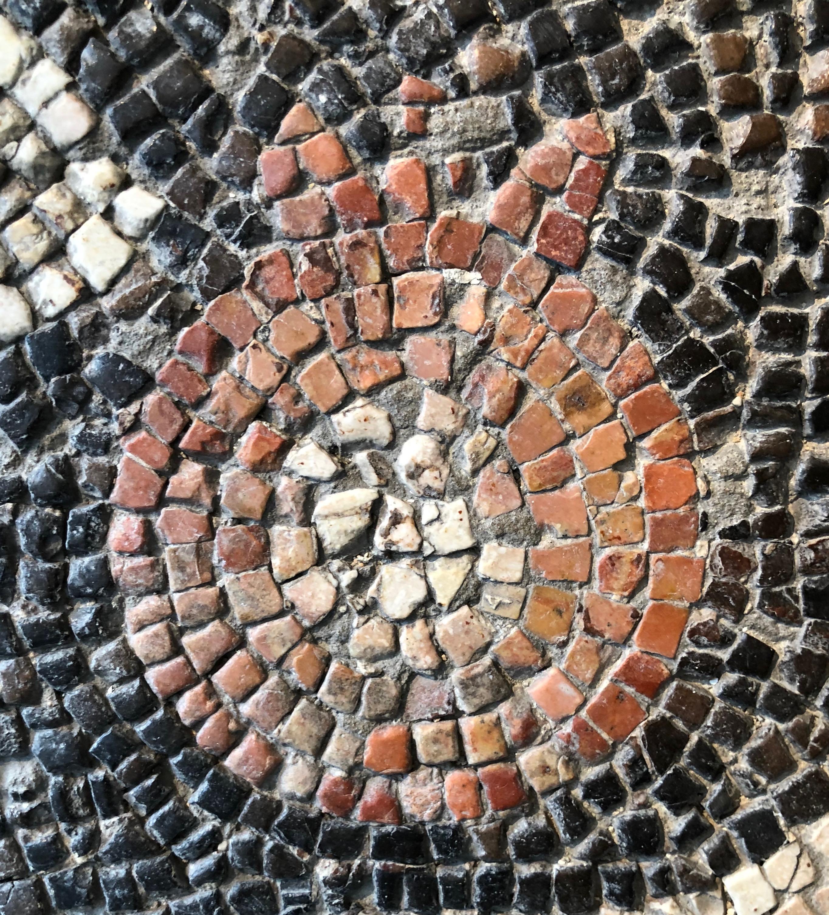 This late Roman circa 4th-5th century AD mosaic fragment designed with a pomegranate in the center, otherwise with an undefined motive making it look very abstract, is a work of art by itself. It is made of small stones or marble squares of