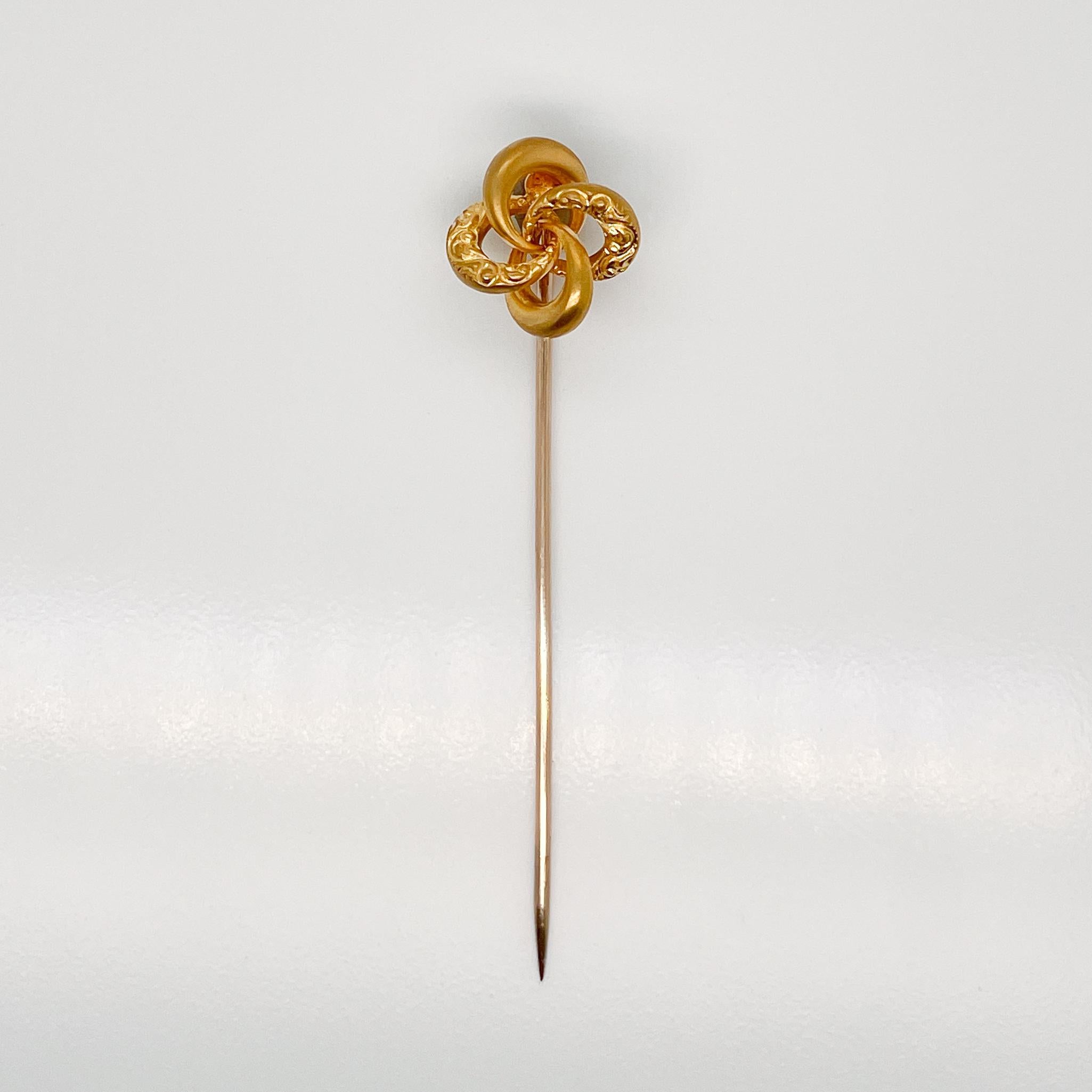 A very fine Late Victorian 10k gold love knot stick pin.

With four interlocking circle shapes in a traditional Victorian Love Knot.

Two links are etched filigree patterns.

Simply a great stickpin!

Date:
Early 20th Century

Overall Condition:
It