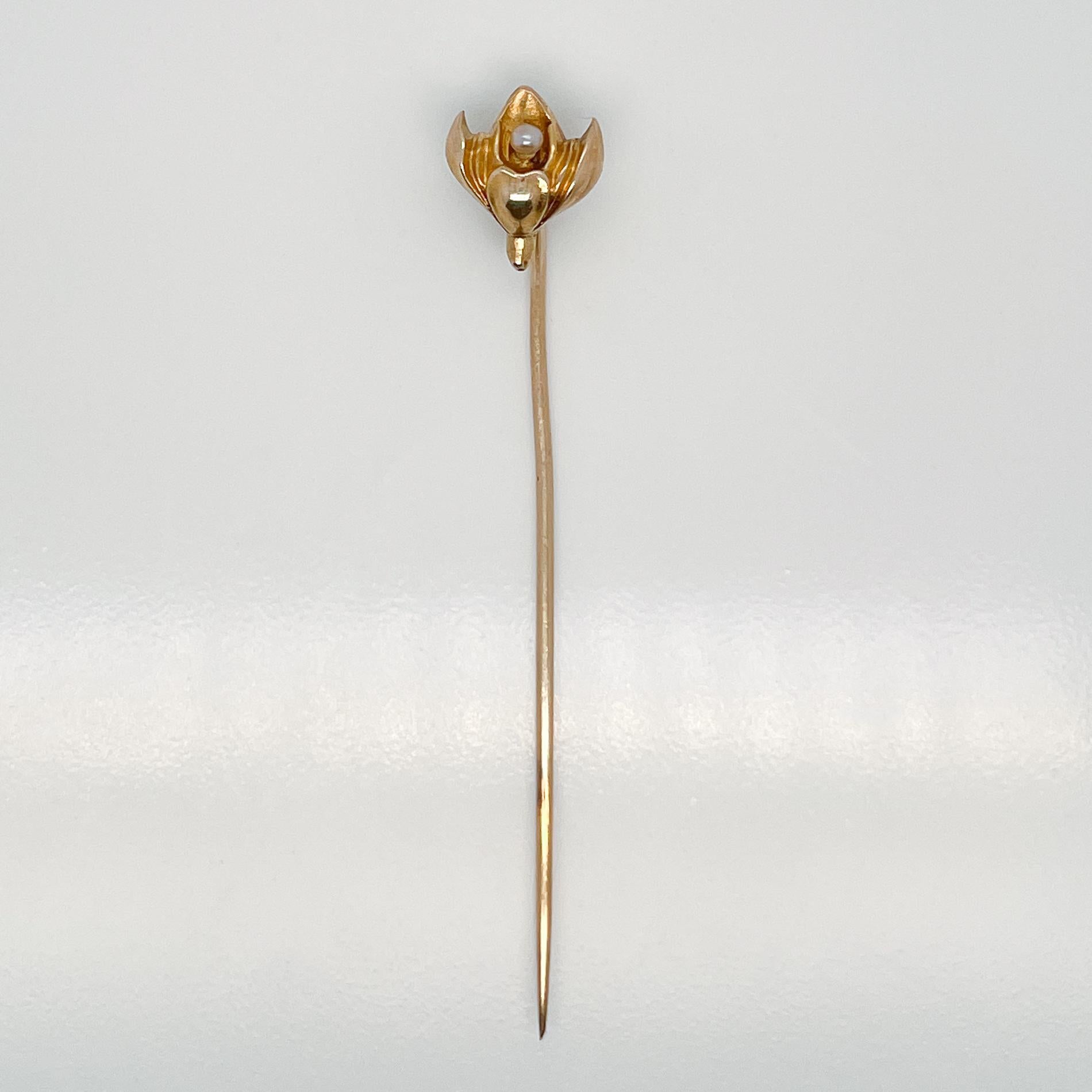 A very fine Late Victorian 10k gold & seed pearl stick pin.

With a lotus shaped flower that has a small white round seed pearl set at its center.

Simply a great stickpin!

Date:
19th Century

Overall Condition: 
It is in overall good, as-pictured,