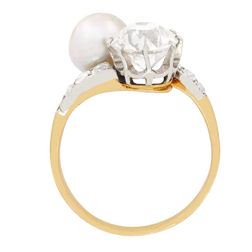 Este anillo giratorio, que data de la década de 1940, presenta una impresionante perla natural de agua salada junto a un glorioso diamante. El diamante de talla antigua pesa 1,70 quilates y tiene una graduación de G en color y SI1 en claridad. Por