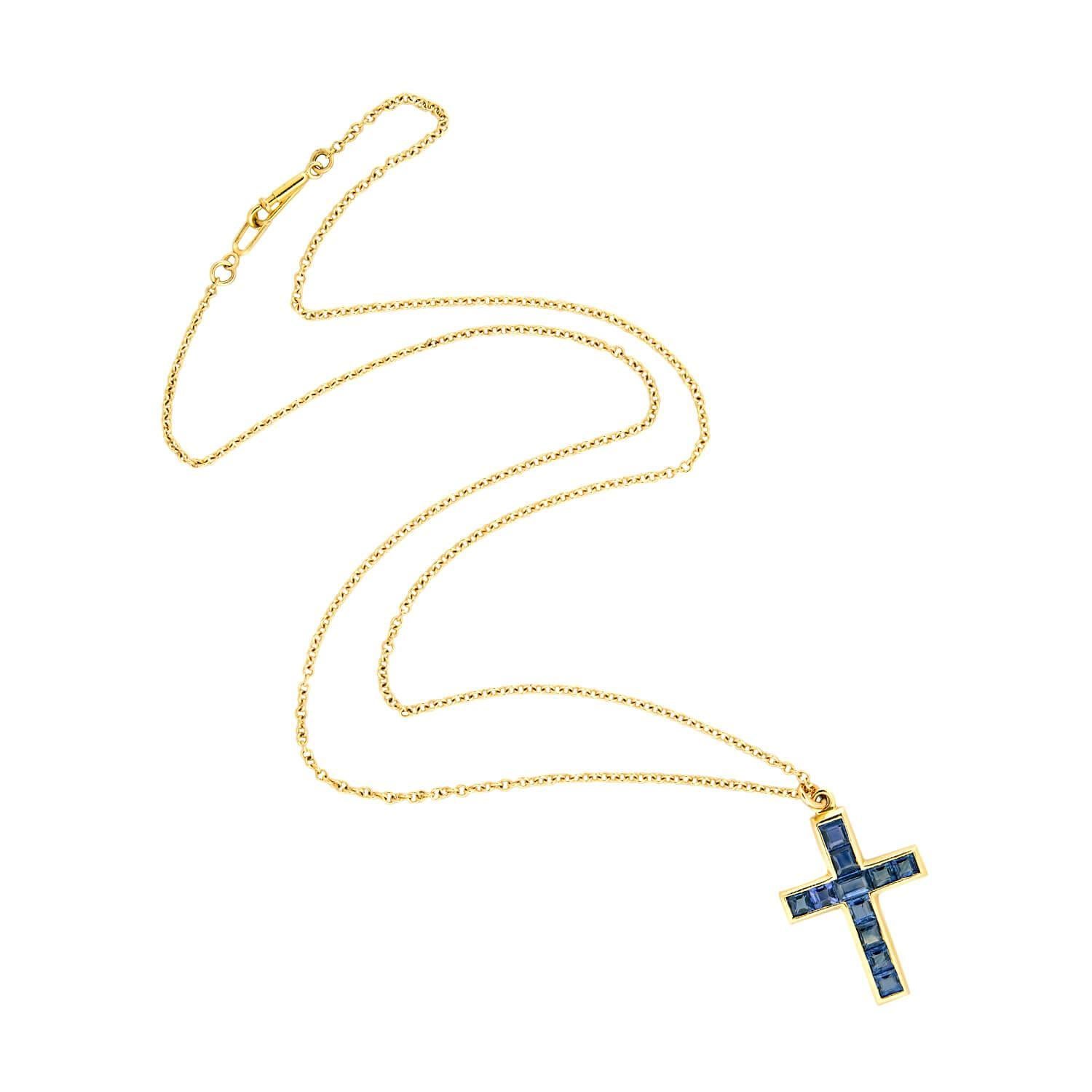 A beautiful sapphire cross pendant necklace from the Late Victorian (ca1900s)era! Crafted in 18k yellow gold, the pendant is lined with 10 square step cut sapphires, and one rectangular cut sapphire. The deep, rich blue sapphires are channel set and