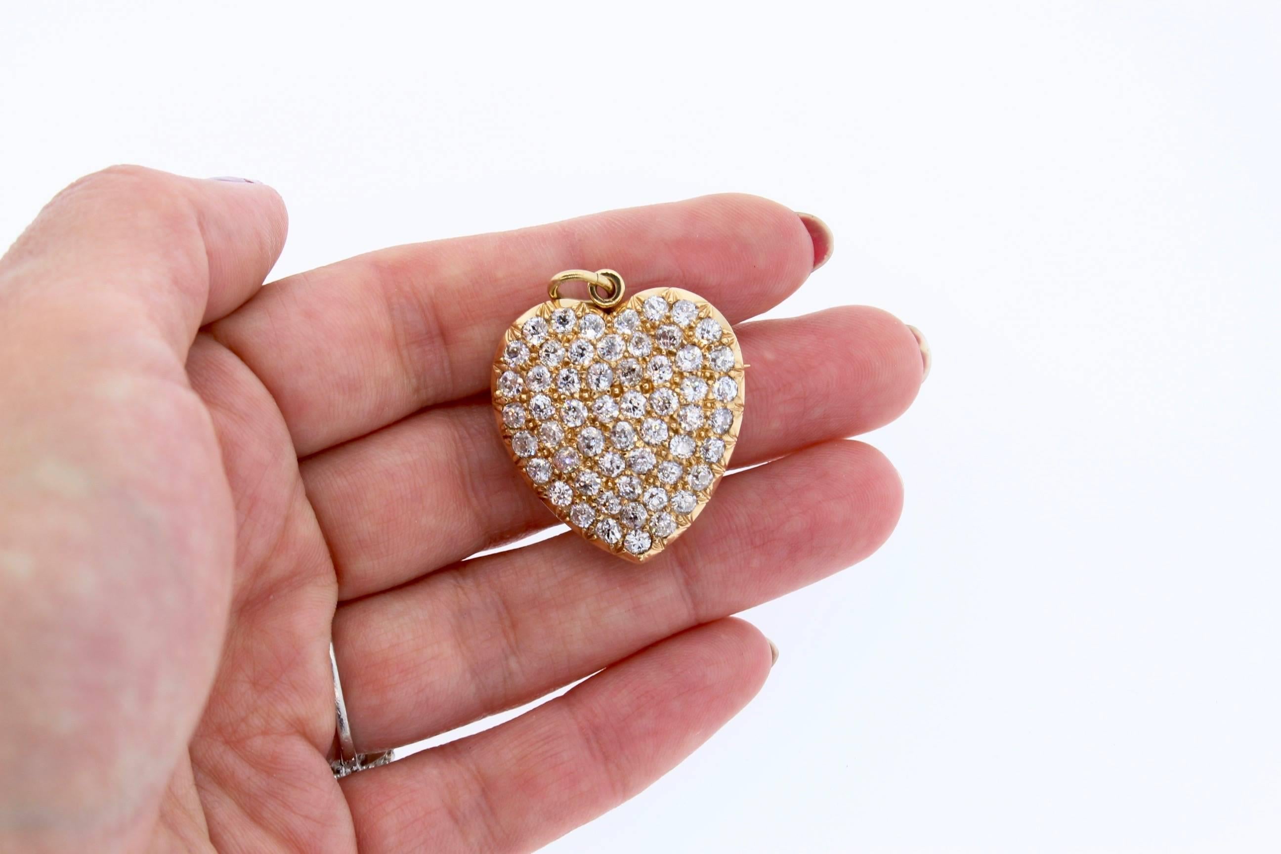 An 18k yellow gold and diamond heart pin/pendant circa 1890.  The pendant has a bail that moves up or down and a pin back which can be screwed to come off the back.  The pendant is set with 55 old mine cut diamonds weighing approximately 7 cts