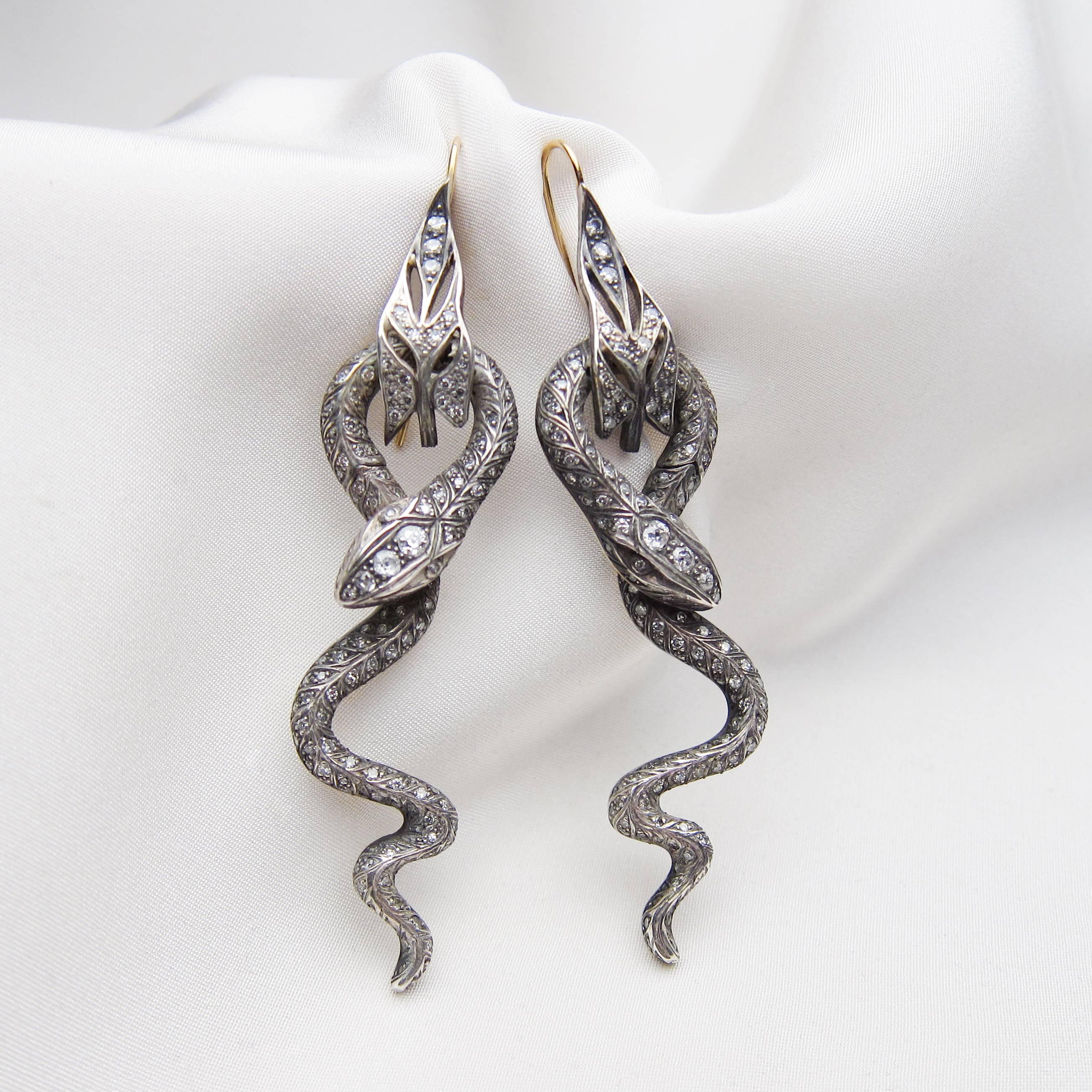 Circa 1900s. These spectacular late-Victorian earrings feature silver-topped 14KT gold snakes slathered with diamonds. Each earring is pave-set with three old European-cut diamonds and 177 single-cut diamonds. The old European-cut diamonds weigh .44