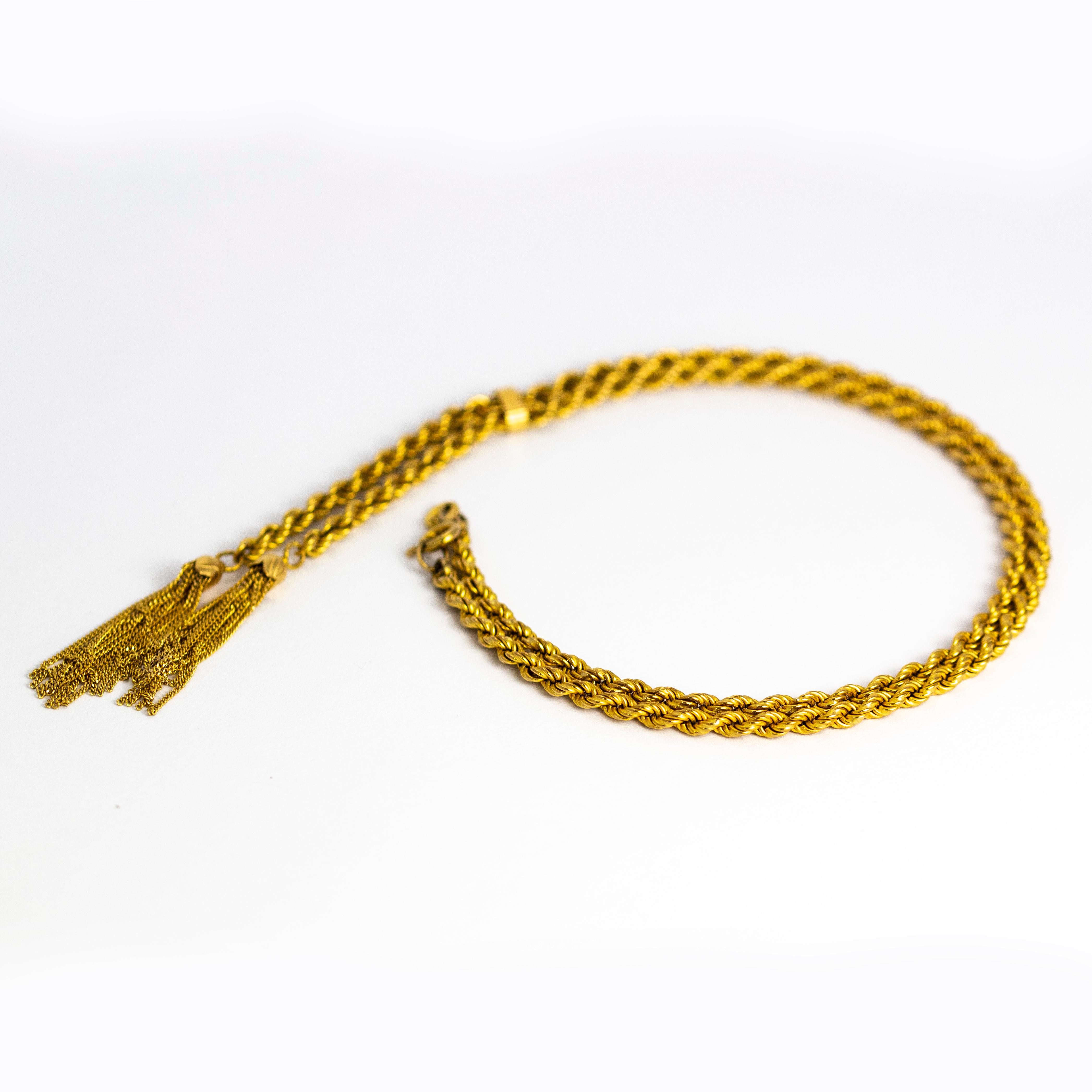 This stylish late Victorian necklace has two delicate tassels which hang on the end of a stunning rope twist chain. The tassels are made up of tiny glistening chains held by gold bells. All modelled in 9ct gold. 

Length: 16inches