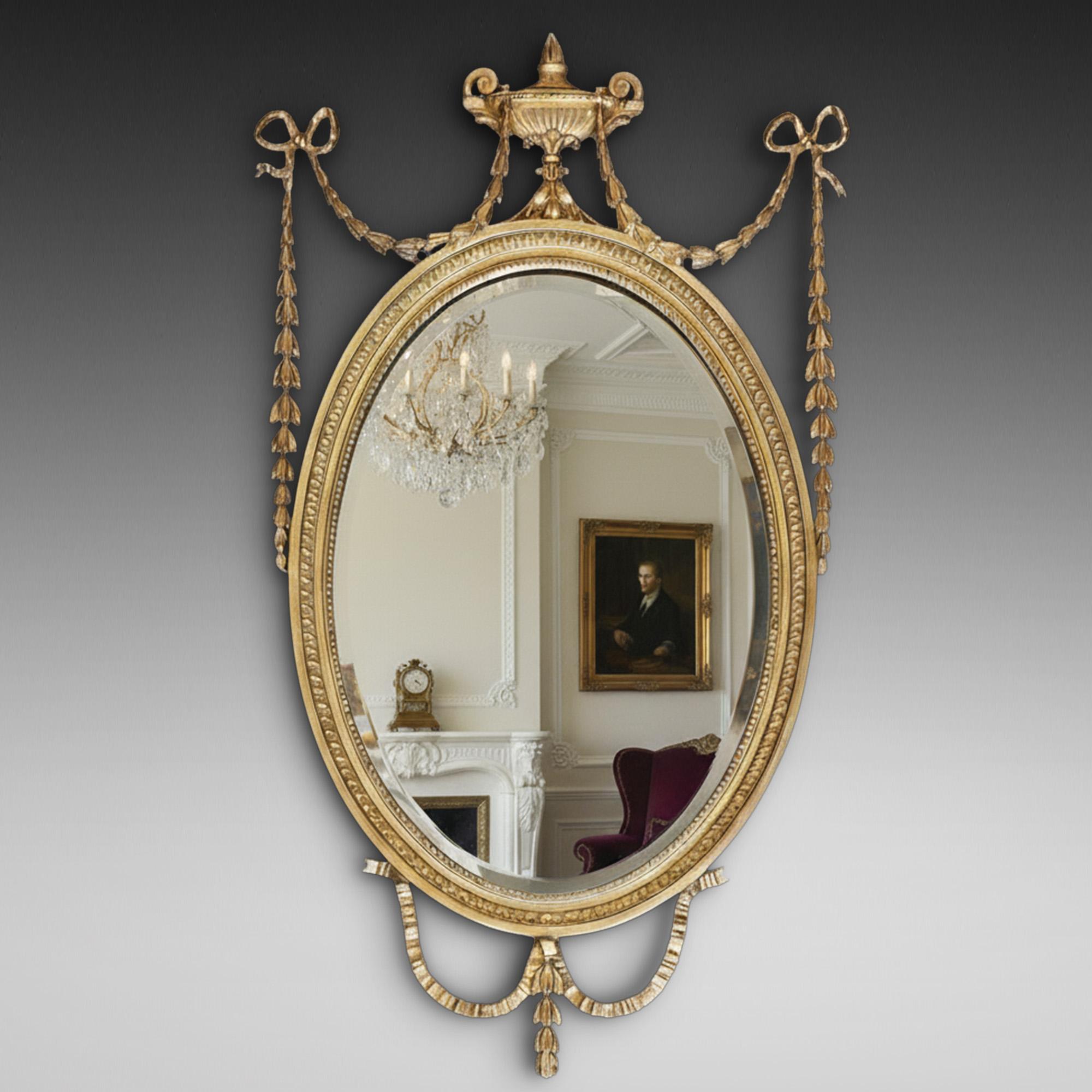 Specchio da parete in legno dorato di epoca tardo-vittoriana Adam Revival - con cornice in perline e modanatura a fogliame, vetro smussato, con nastri legati a campane di lepre pendenti con al centro un'urna classica, con nastro e grembiule a