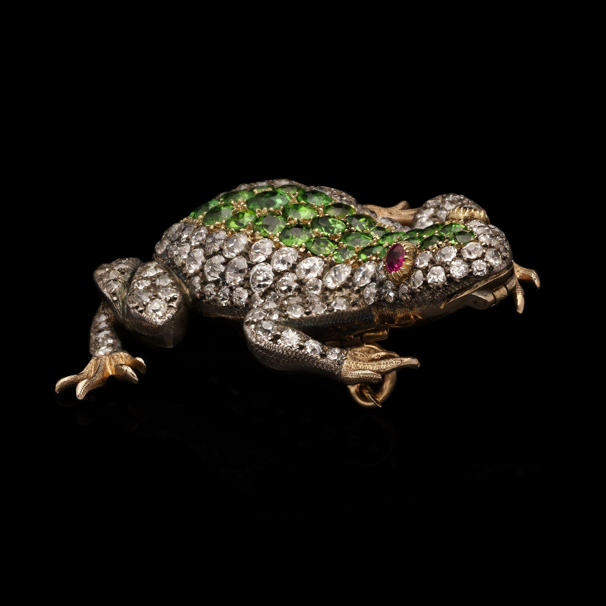 A wonderful late Victorian demantoid and diamond frog brooch/ pendant, circa 1890, the frog formed in silver on gold with gold feet and pavé set throughout with bright and lively old cut diamonds, the central panel down its back is set with