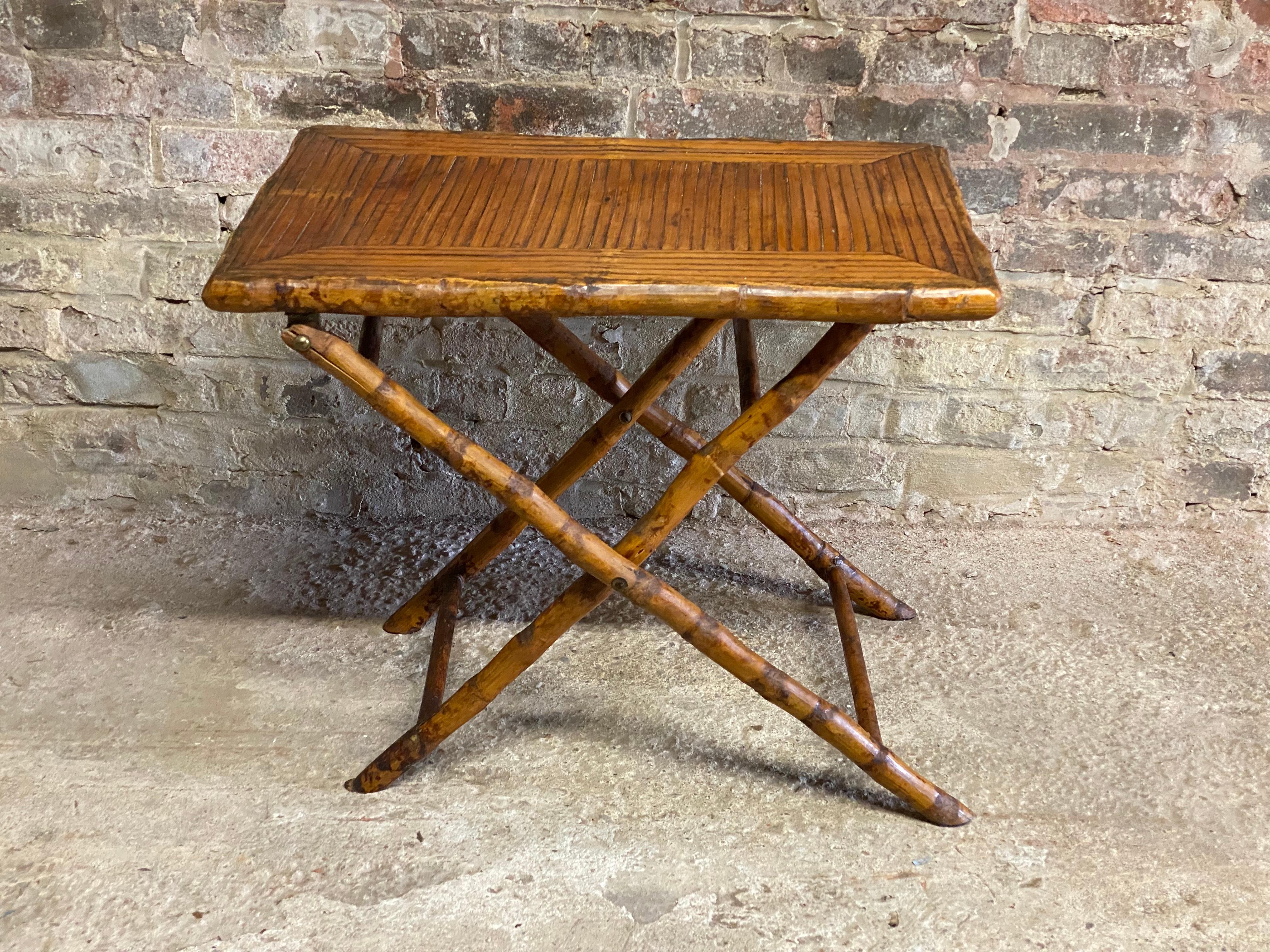 An amazingly versatile Late Victorian Bamboo folding table. The durability and fine decorator quality of old bamboo cannot be matched. Green, environmentally correct and renewable before it was a glimmer of a thought. The top is made of split bamboo