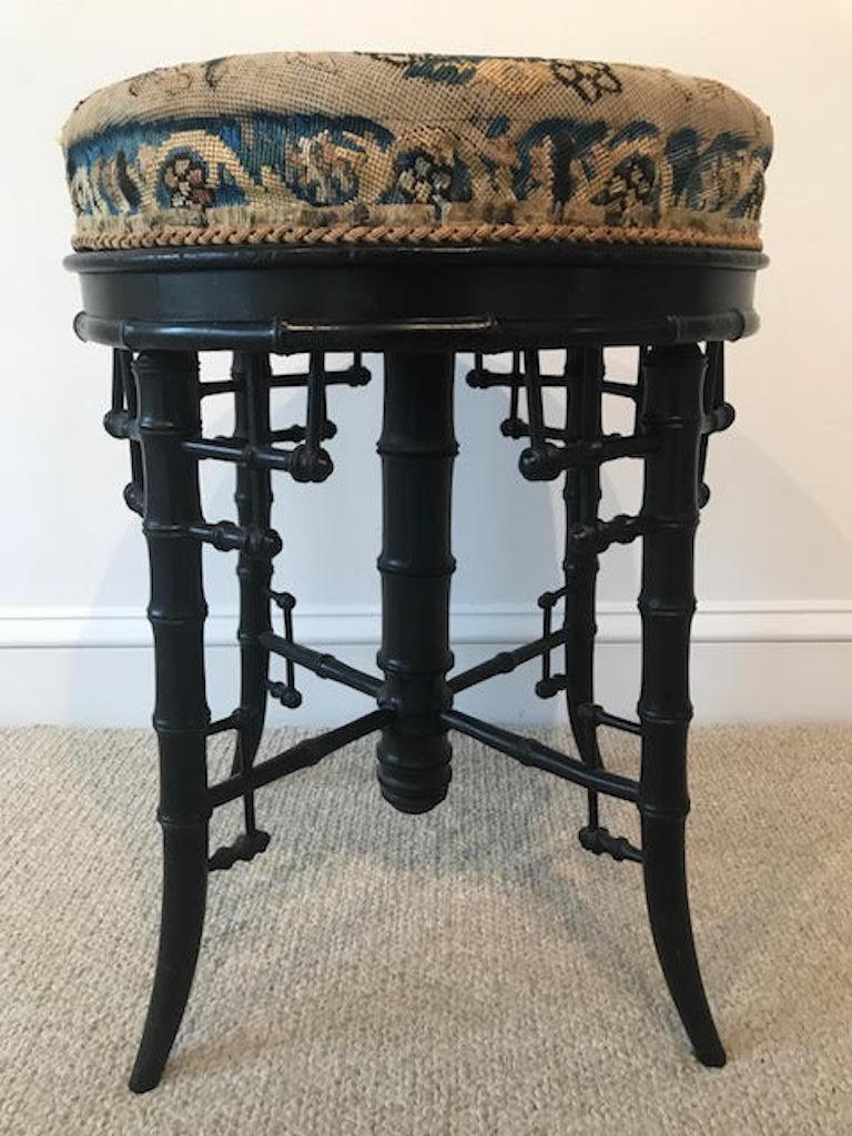 This stunning seat still bears the original Linda horn label. Ebonized bamboo and partially completed needlepoint complete a stunning picture. The piece conveys a warmth and character consistent with its age and elegant wear.