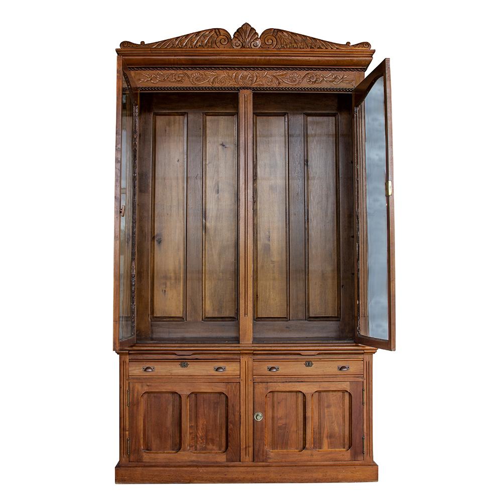 This solid ash two-piece bookcase is a great example of traditional Victorian-era furniture. Two drawers, as well as two lower cabinets, provide concealed storage The upper case, with its original wavy glass, allows for the display of special