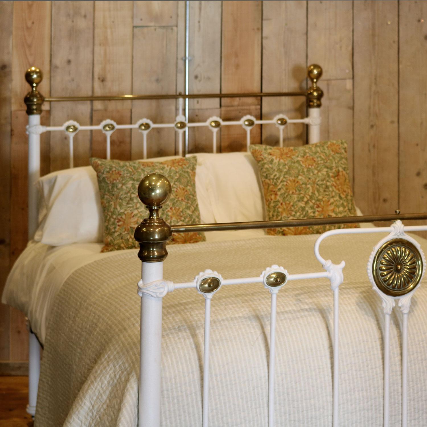 Late Victorian brass and cast iron bedstead, finished in cream with straight brass top rail and striking brass centrepiece in the foot board with a flower design. This bed also has some lovely mouldings with brass detailing throughout. 

This bed