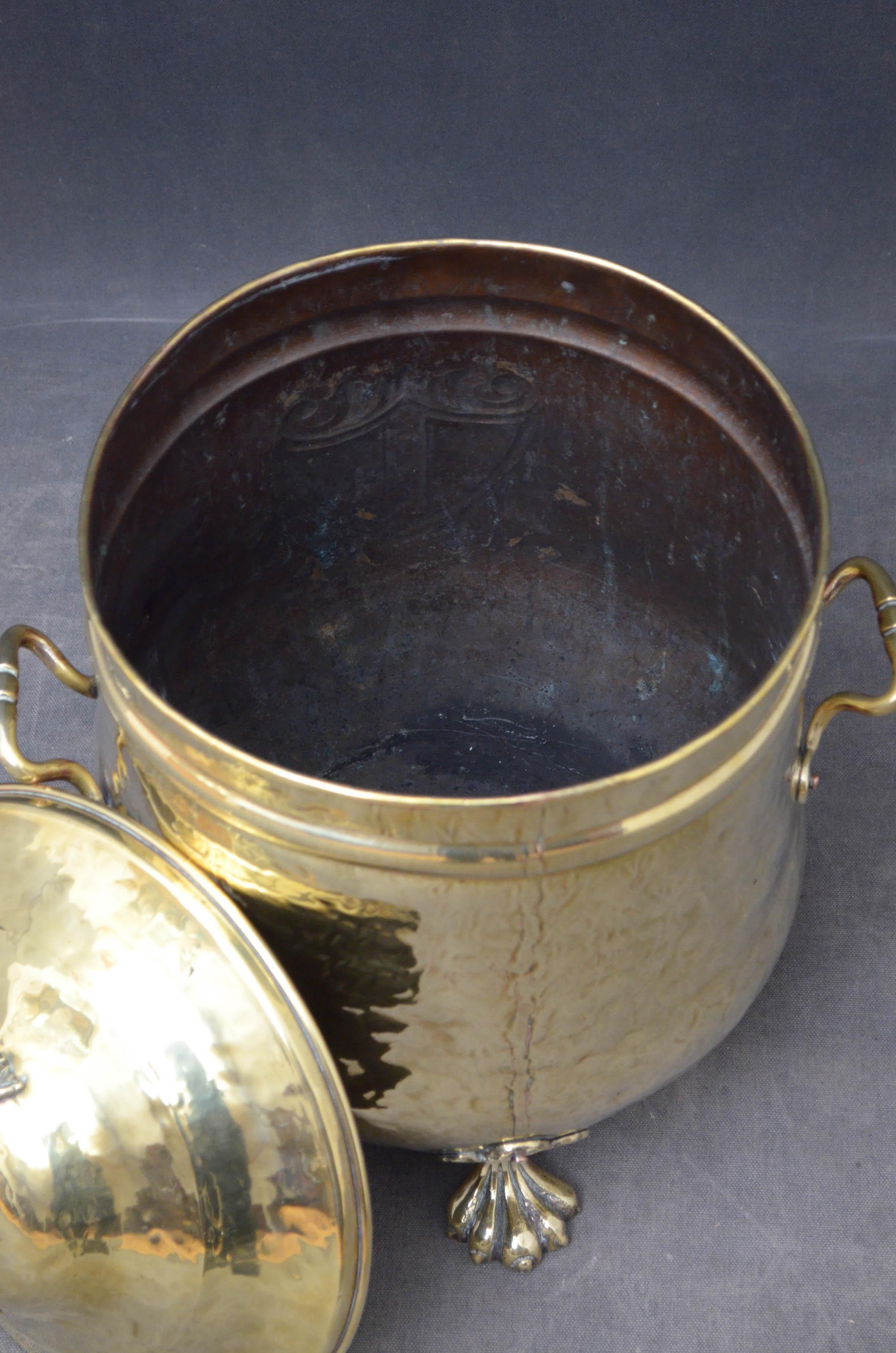 J00 Stylish late Victorian coal bucket in brass, having lift up lid and 2 carrying handles and heraldic symbol to the front, standing on 3 paw feet.

This antique coal bucket is in home ready condition, circa 1890

Measures: H 20