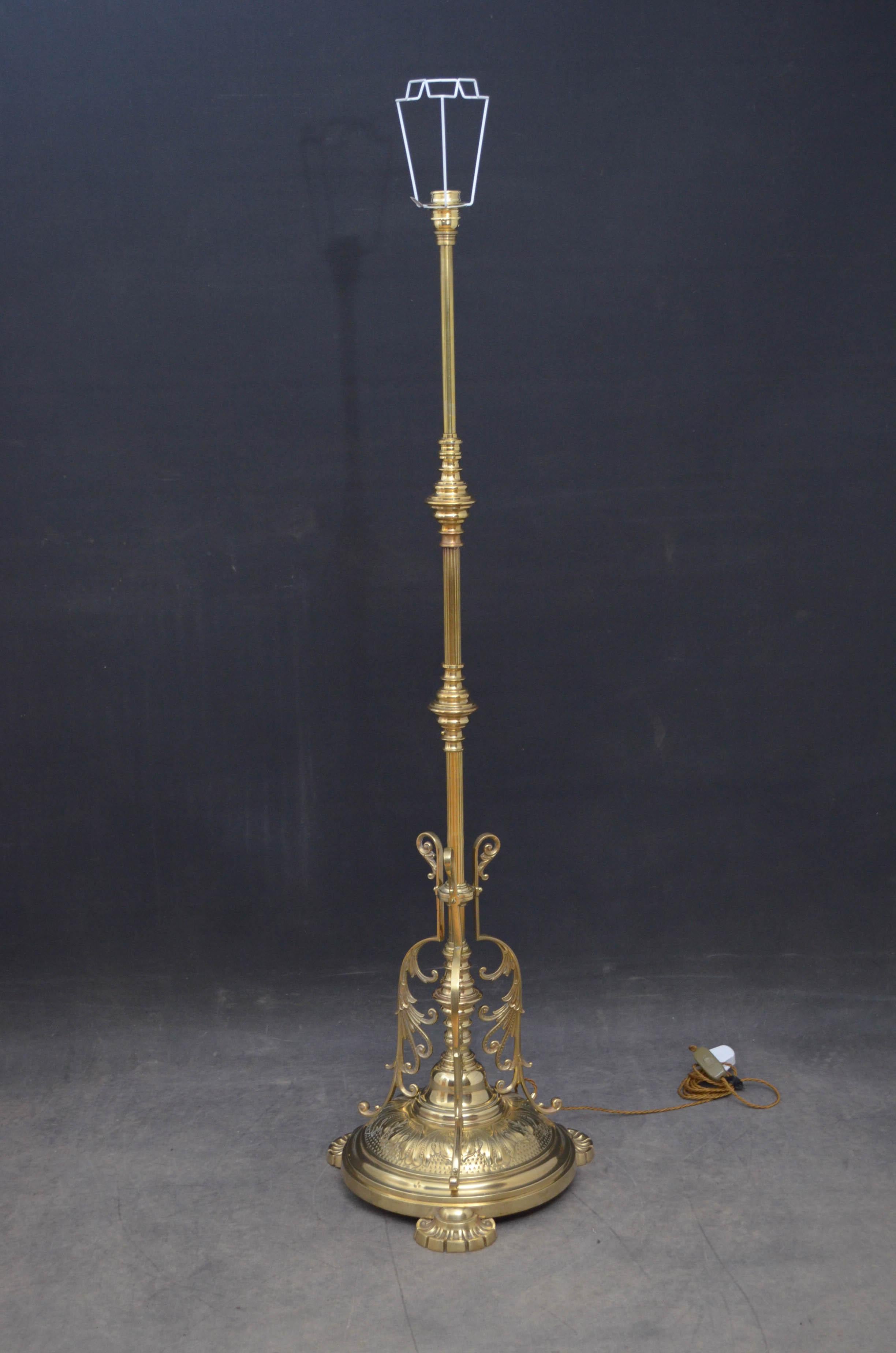 Attractive late Victorian brass floor lamp with reeded column and substantial circular base decorated with acanthus leaves and three scrolled supports, standing on fluted pad feet. This antique lamp has been professionally rewired and is ready to