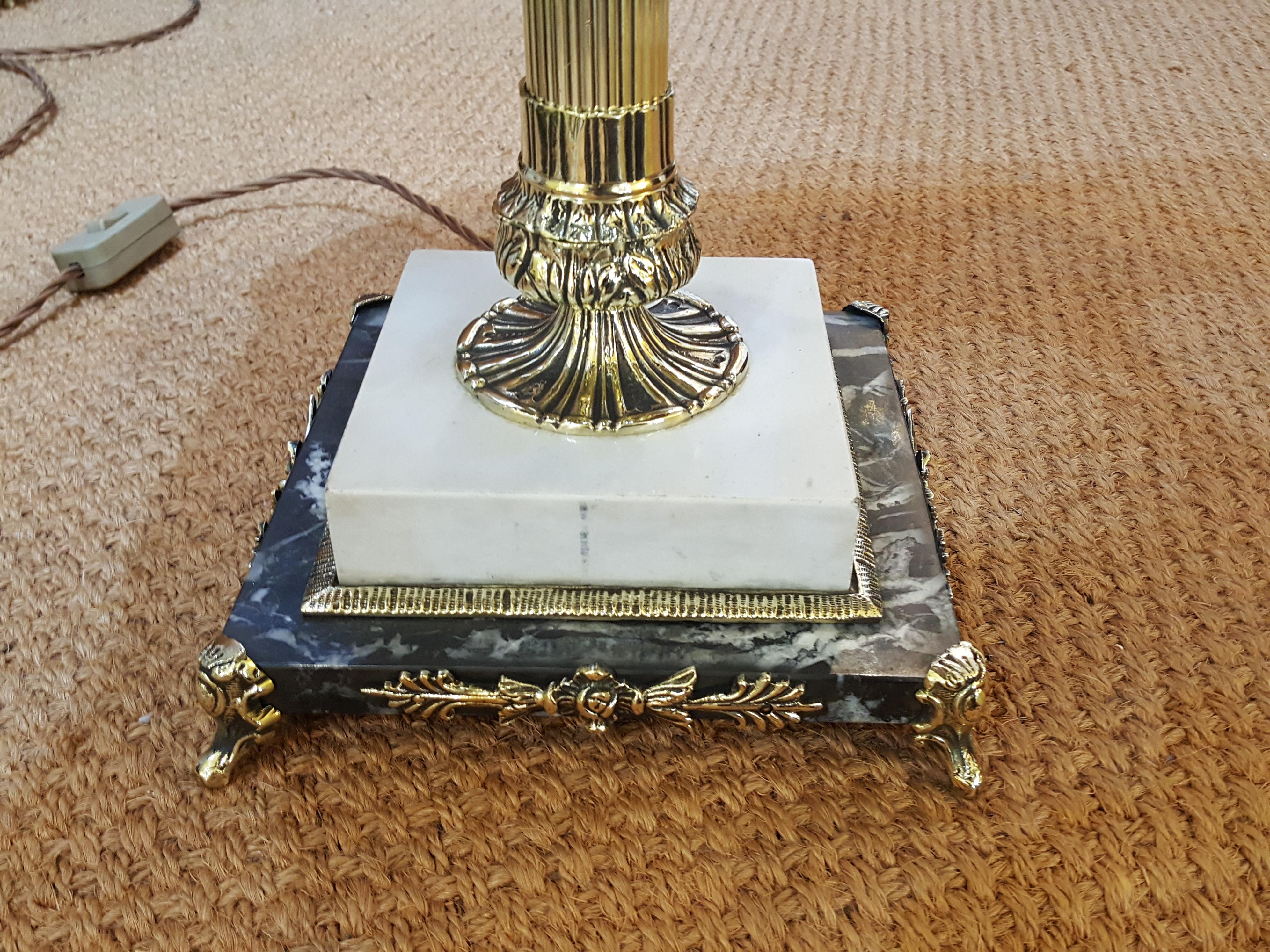 Late Victorian brass table oil lamp, in neoclassical style, as a fluted column on a stepped white and grey marble base with mask and scroll feet, converted to electricity, the lampshade(s) are newly handmade silks by the same maker as provides the