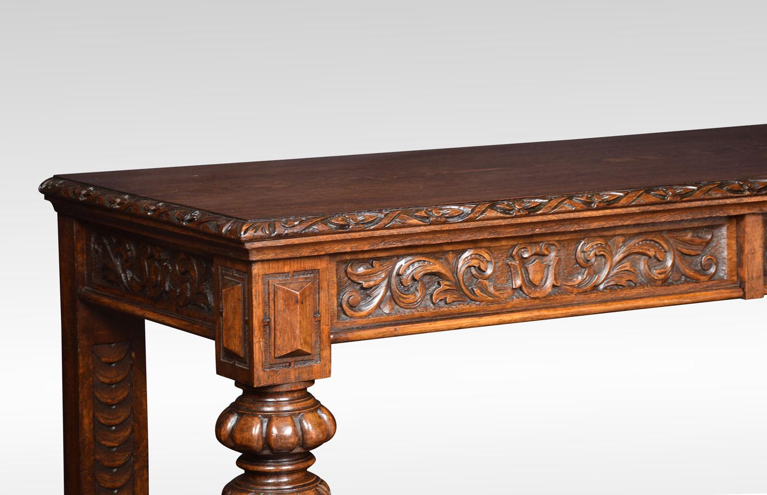 Late Victorian carved oak two-tier buffet, the rectangular top above two freeze drawers carved with Primitive floral blind fretwork. Supported on vase shaped columns, with under tier below. All raised up on similar vase shaped supports terminating