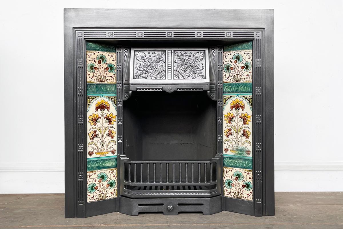 Late Victorian cast iron fireplace insert in the Aesthetic manner, circa 1890. Pictured with a set of original antique fireplace tiles, These tiles have now sold, but we have over 200 sets of original fireplace tiles available.

The cast iron has