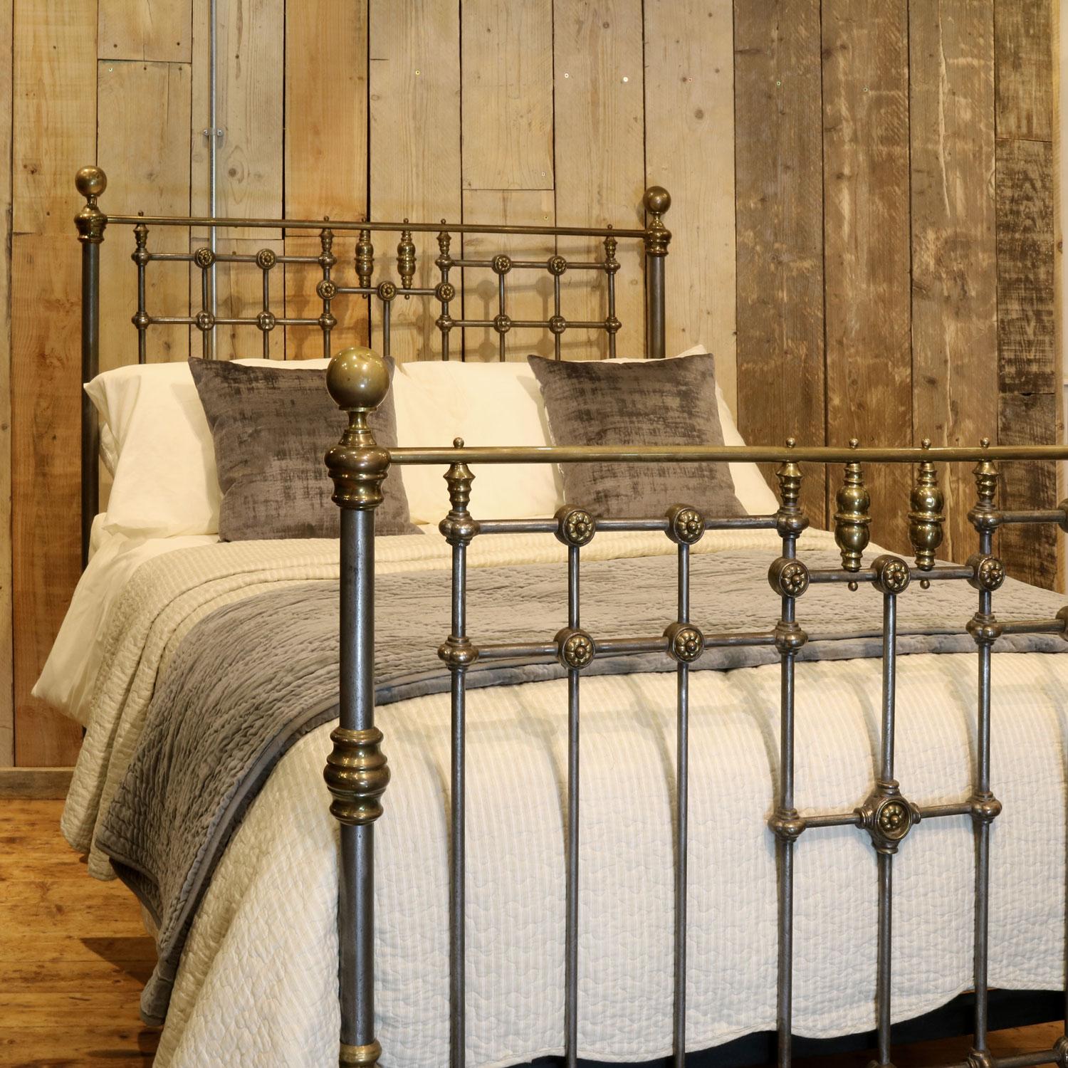 Late Victorian brass and cast iron bedstead with burnished steel finish. The head and foot ends have delicate brass flowers, and the footboard has a lovely central design featuring brass spindles. 

This bed accepts a double size 4ft 6in wide (54
