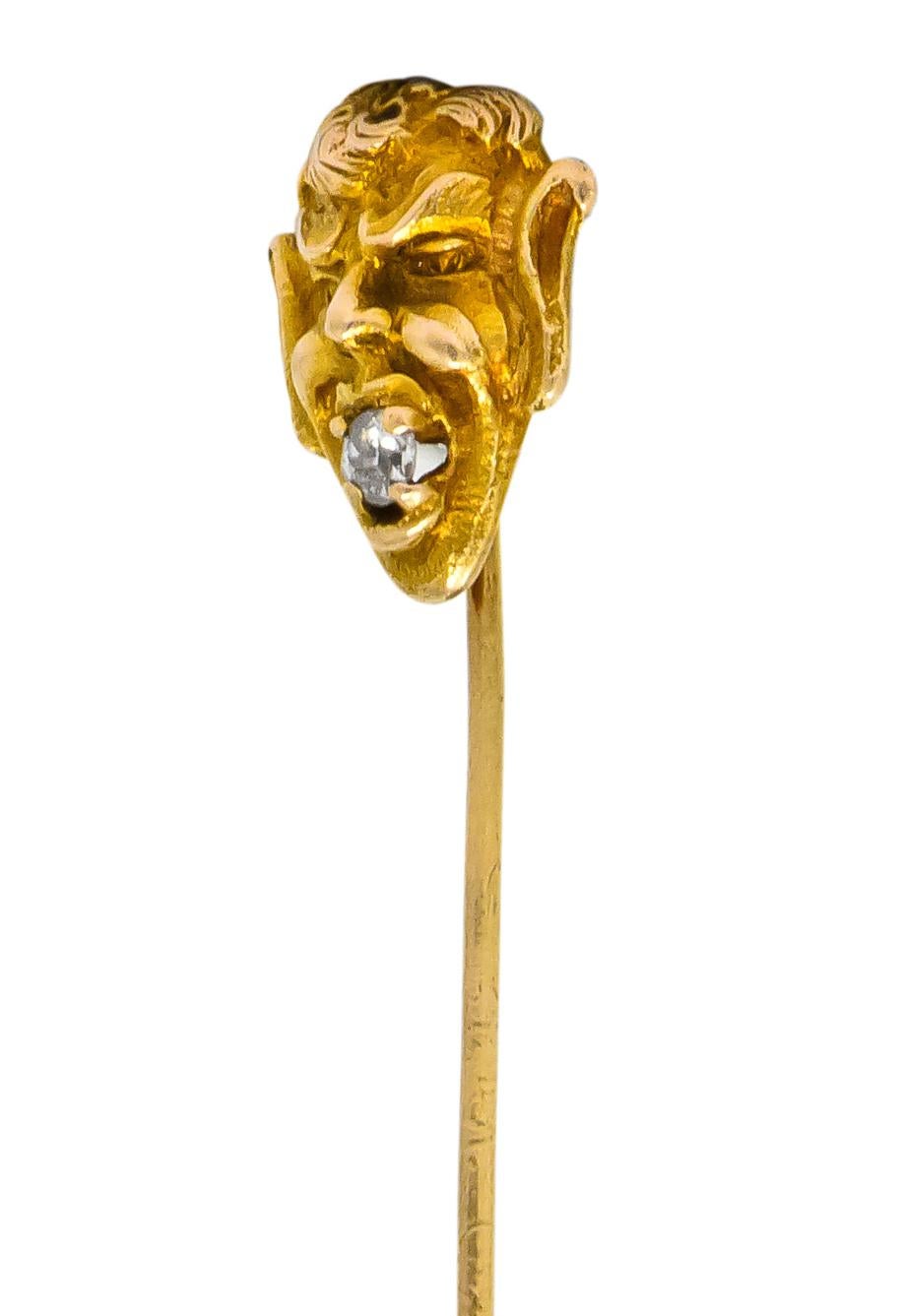 Depicting the elvish face of the Greek god Pan holding a diamond in his mouth 

Old European cut diamond weighing approximately 0.10 carat, eye-clean and white

Detailed gold with curled hair and over-sized ears

Tested as 10 karat gold

Man