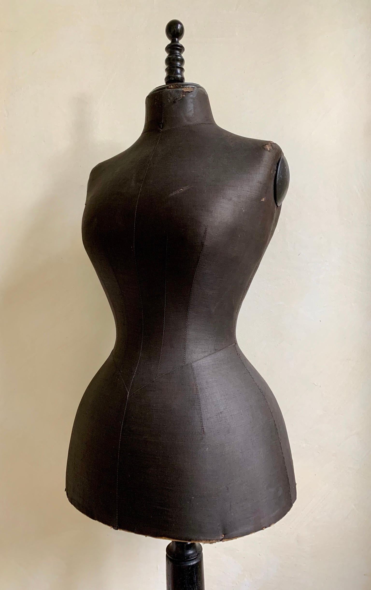 Original condition dummy in ebonized wood finials and black silk finish on body on tripod base.
Wasp waist and wide hip dates this to late 19th century.