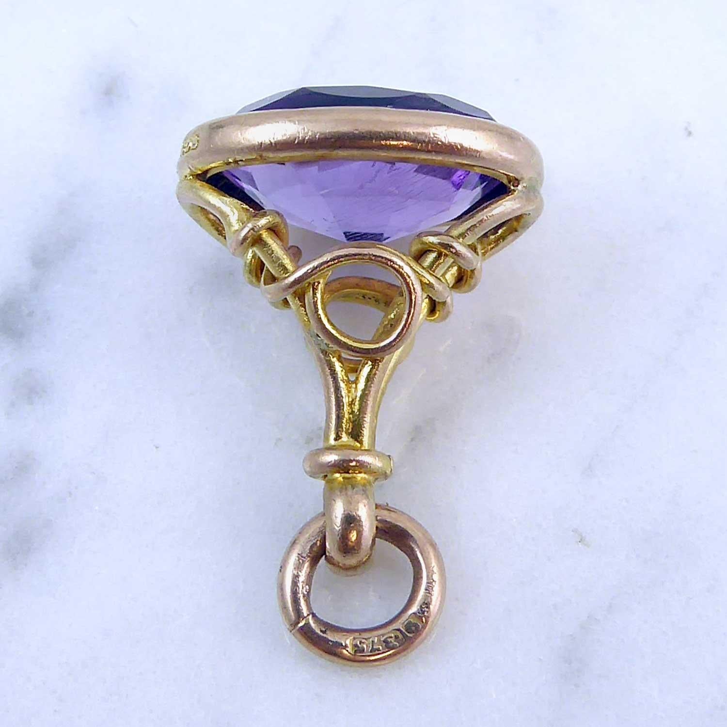 This is such a sweet antique fob - a perfect size to wear on a neck chain.  A decorative scroll and knot style mount, hand made in 9ct rose gold holds an oval faceted amethyst in which the typical 