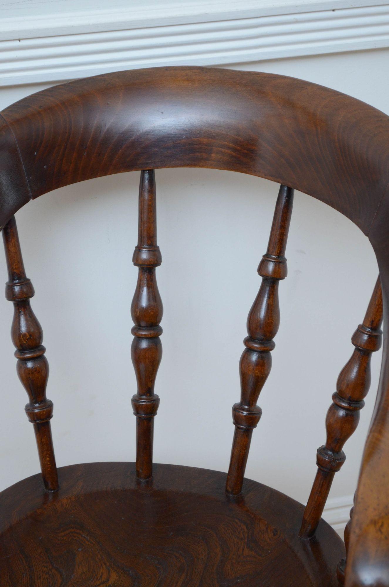 Sn5356 Late Victorian desk chair with shaped top rail supported on spindles, generous elm seat and downswept arms, standing on turned legs united by double stretchers. This antique chair is in home ready condition. c1880.
H18.5
