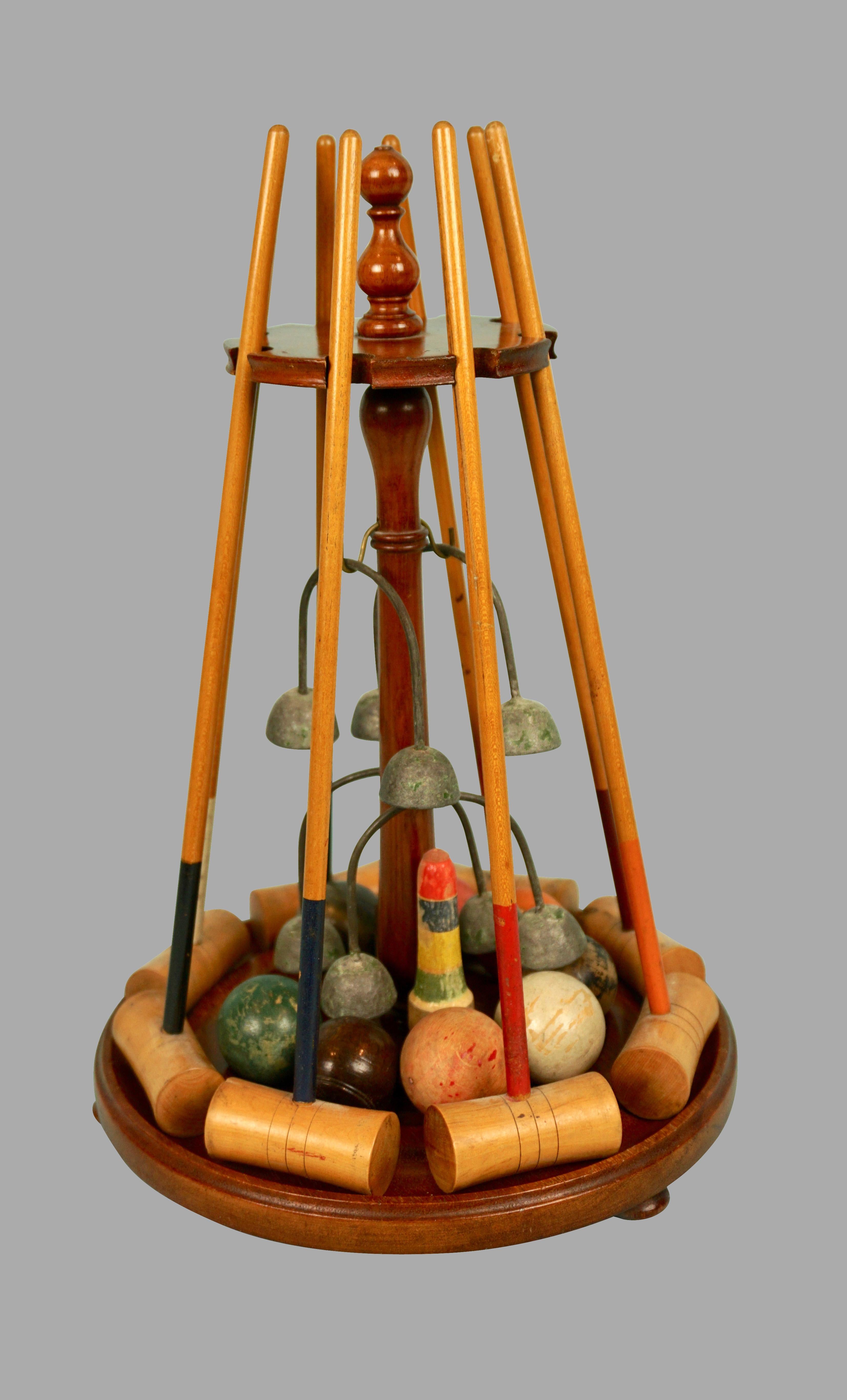 A wonderful antique miniature croquet set consisting of multiple mallets, wickets and balls, all mounted on a beautifully made mahogany rack. A charming and unusual piece of English whimsical craft. Some elements lacking. Circa 1900.