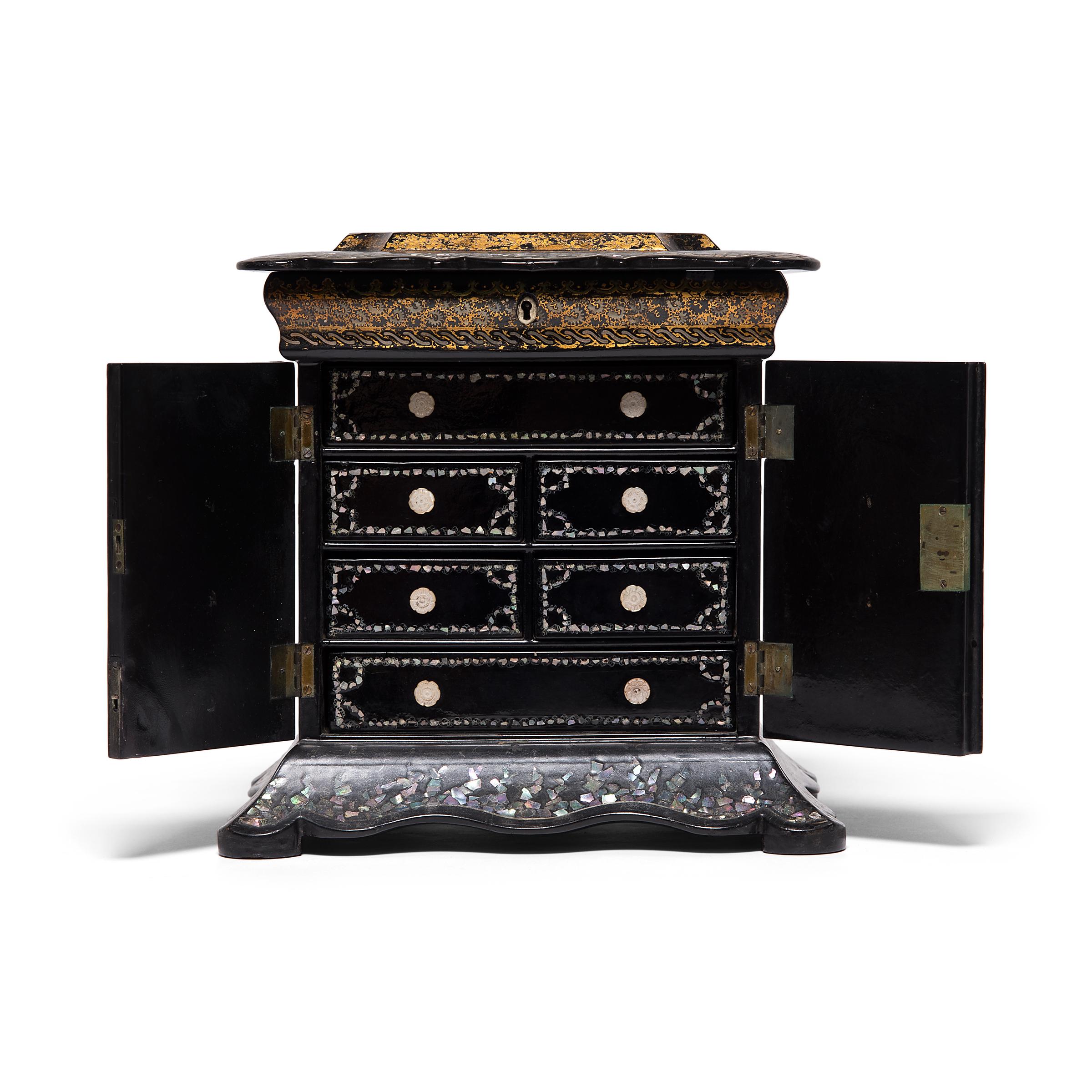 Diese kostbare englische Tischschatulle aus dem 19. Jahrhundert ist mit Perlmuttintarsien und geschnitzten Muschelschubladen ausgestattet. Die Oberseite des Stücks ist mit einer gemalten Landschaft und einer gotischen Kirche verziert, in die