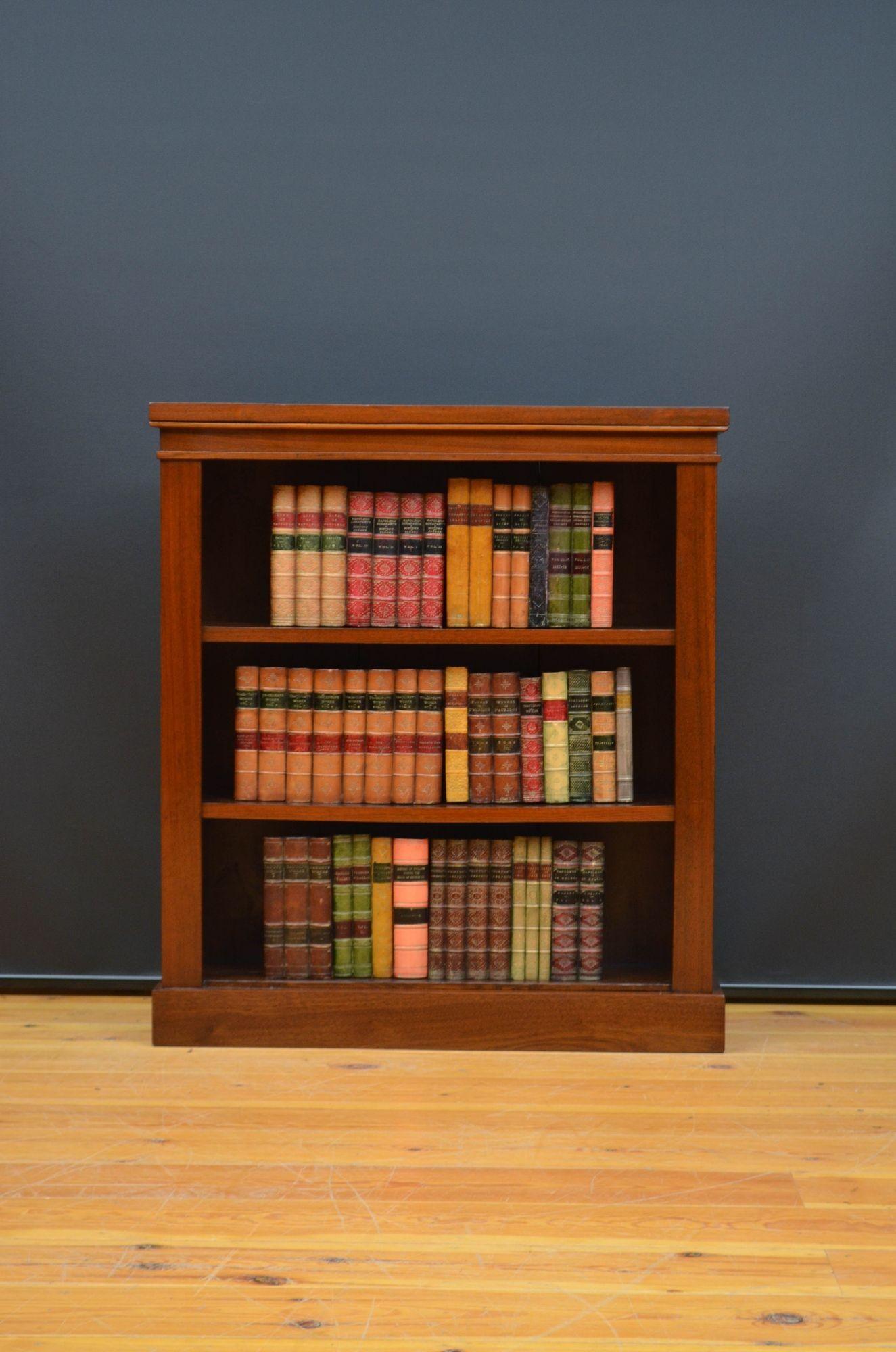 Sn5468 Late Victorian / Edwardian figured walnut open bookcase of unusually narrow proportions, having oversailing top above a shallow frieze and two height adjustable shelves, all standing on plinth base. This antique bookcase has been