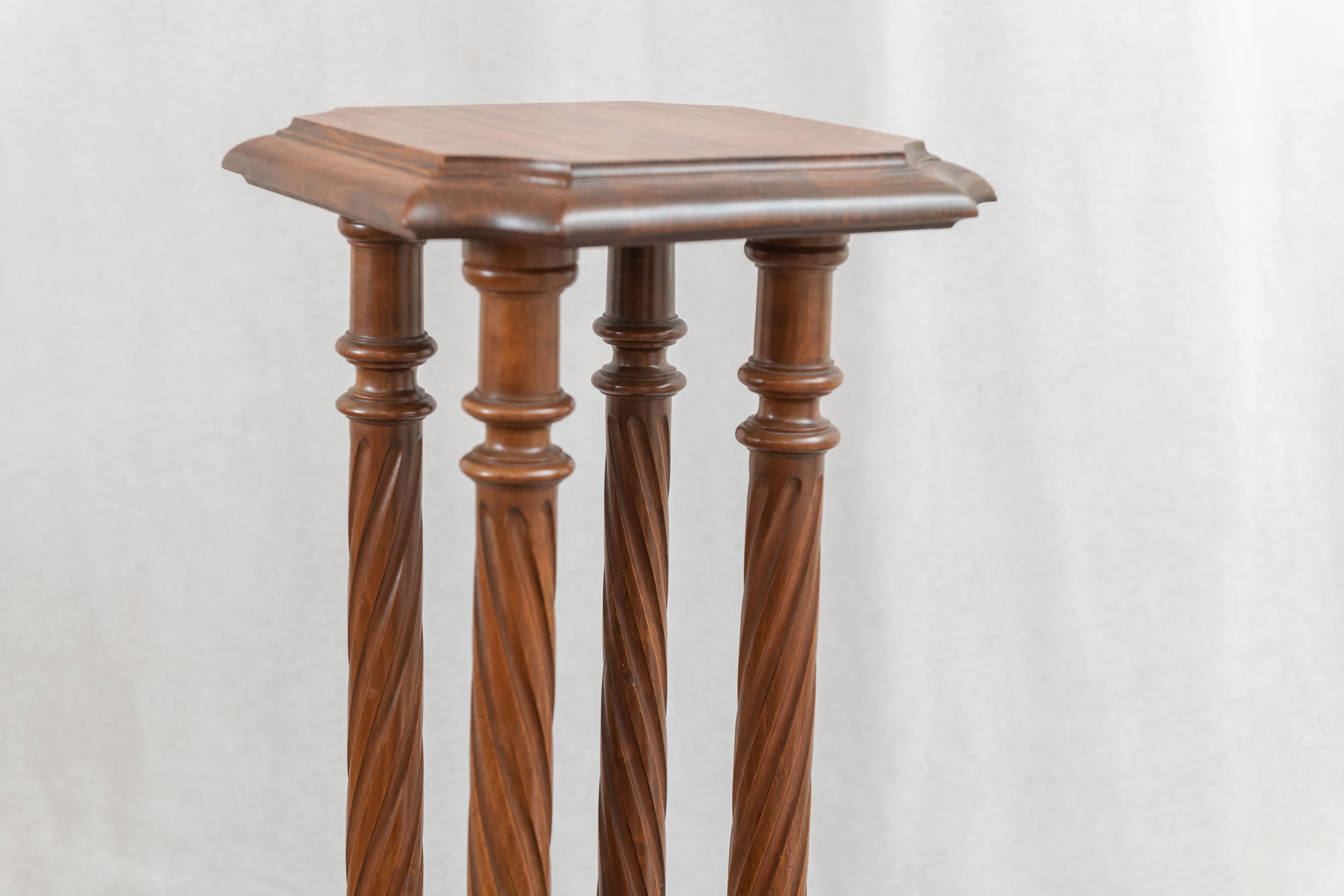 This unusual pedestal has 4 barley twist columns leading up a top which has 4 curved corners. The center of the top is raised and cut back, and adds interest to its look. The base is substantial and works well with the overall look. 
 We have listed