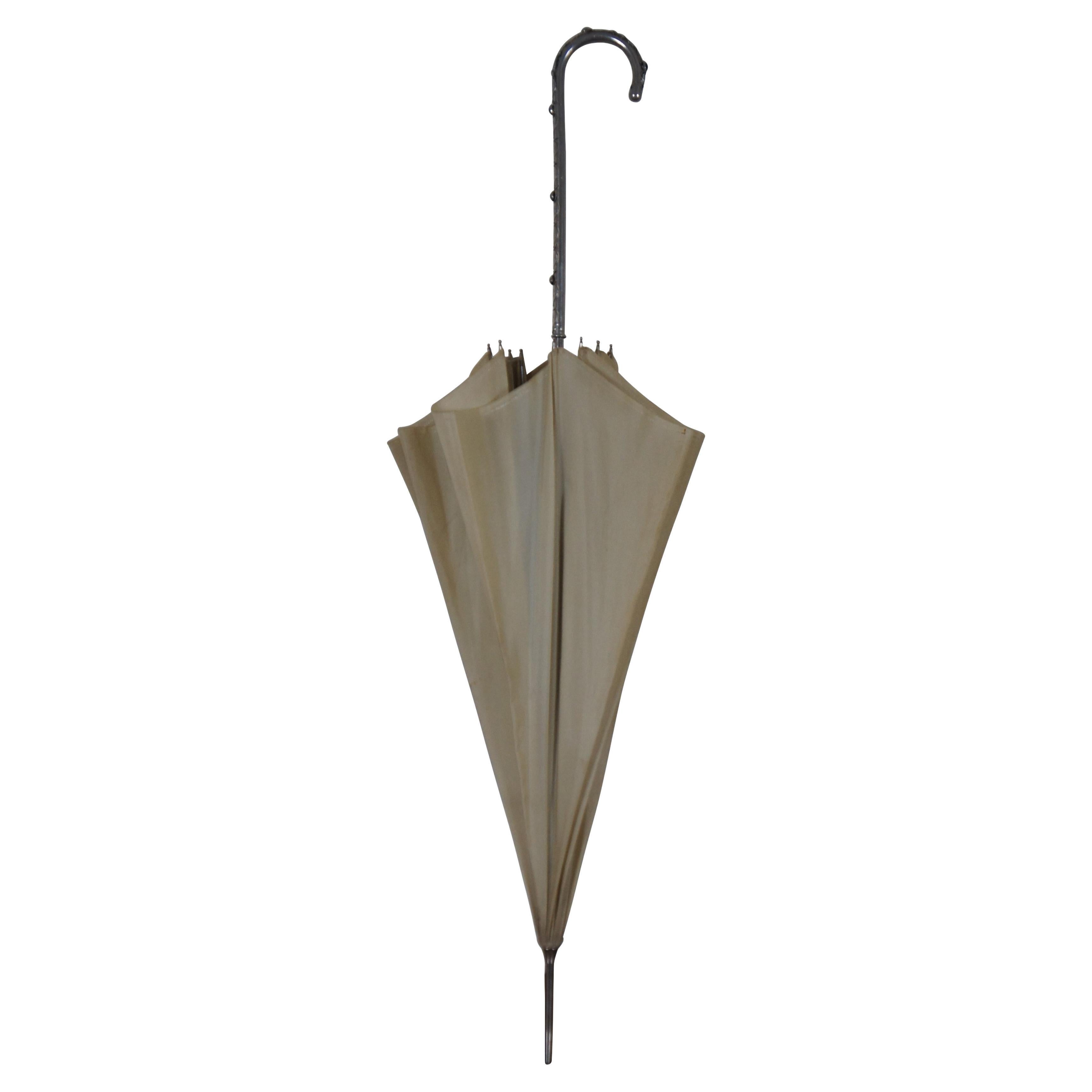 Late Victorian beige umbrella or parasol with silver handle decorated with a molded pattern of leaves and green glass jewels; labeled Fraclem -Florence, Made in Italy.

1.75” x 33.25” / Open Diameter – 34.5” (Diameter x Height)