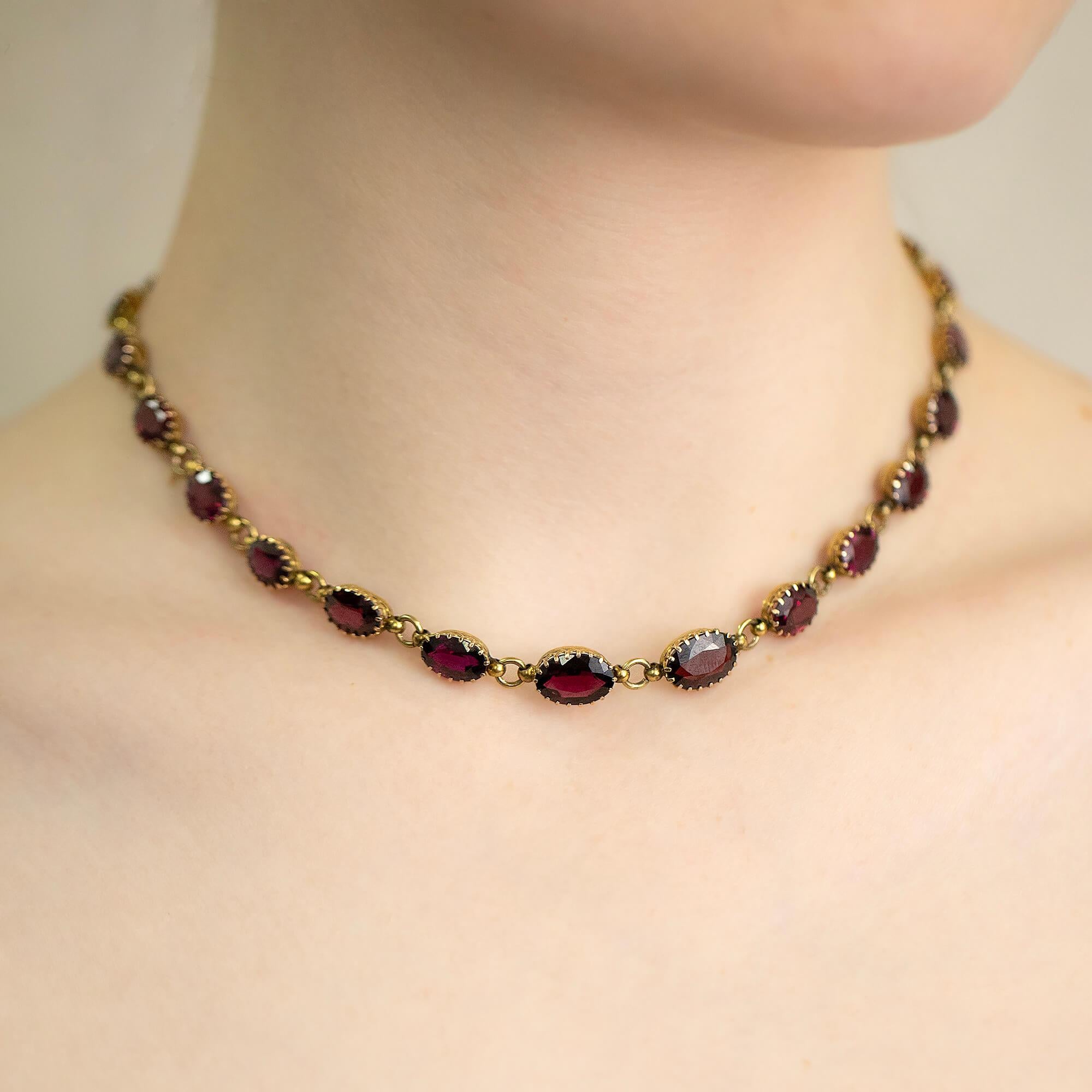 Late Victorian pyrandine oval garnet and gold link necklet. 
Each garnet is set in a claw oval coronet setting with a gold link between each setting. These settings are delicately interconnected, creating an extraordinarily flexible and adaptable