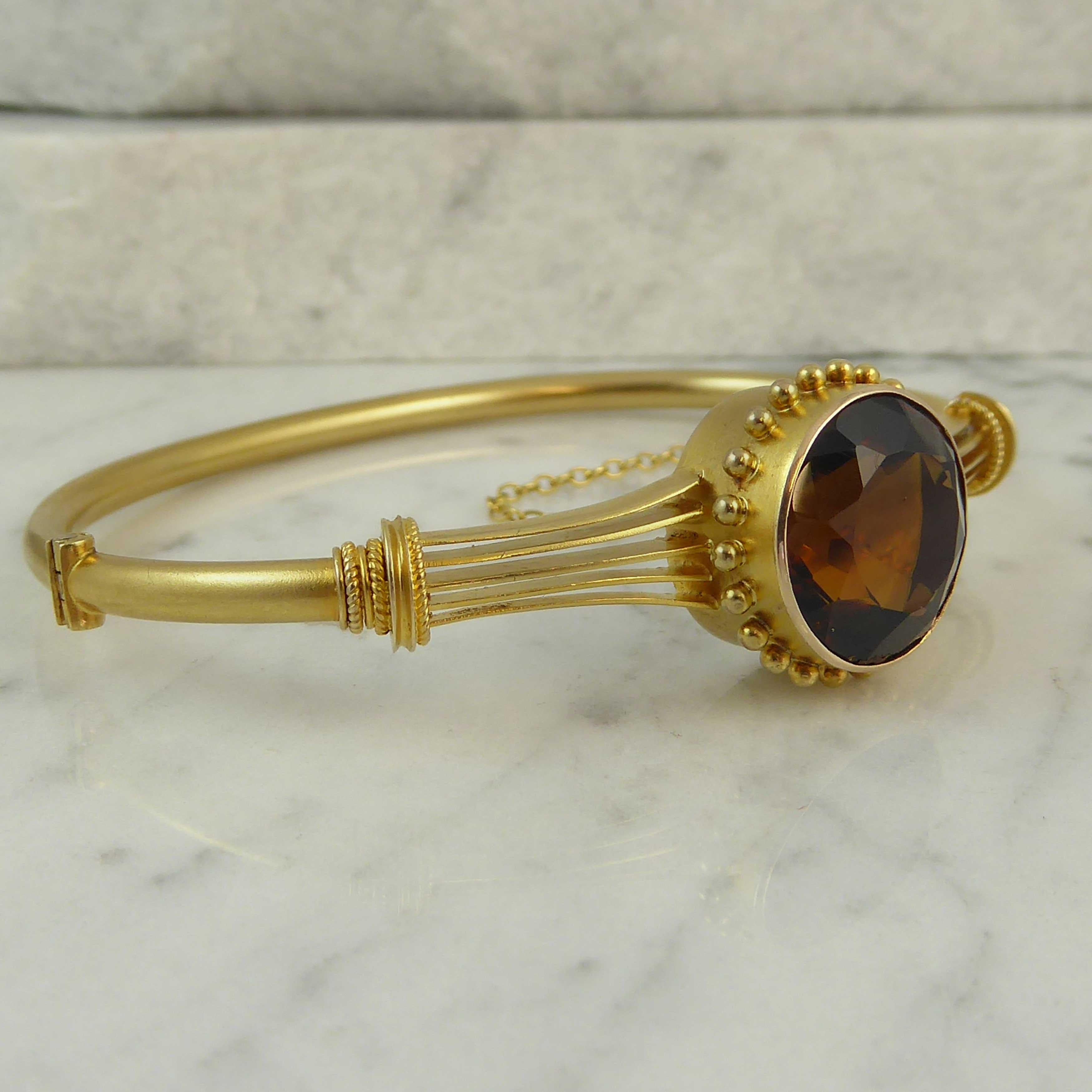 Dating from the latter part of the Victorian era this beautiful bangle is wrought in 15ct gold and displays classical elements typical of the era.  The bangle is set with a dark amber toned Cairngorm Quartz in a collet setting 0.32 inch deep and
