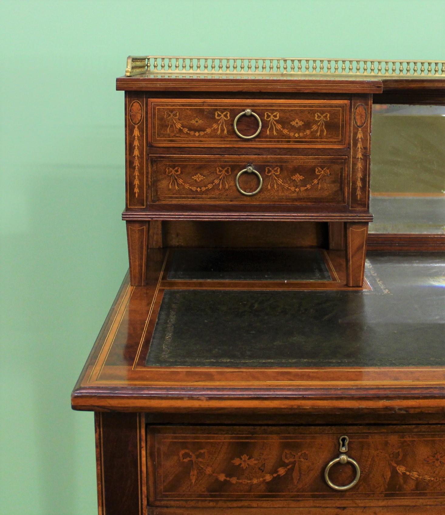 A fine quality late Victorian period inlaid mahogany writing desk. Well-constructed in solid mahogany with attractive mahogany veneers. Decorated throughout with inlaid stringing and satinwood banding. Further embellished with intricate inlaid