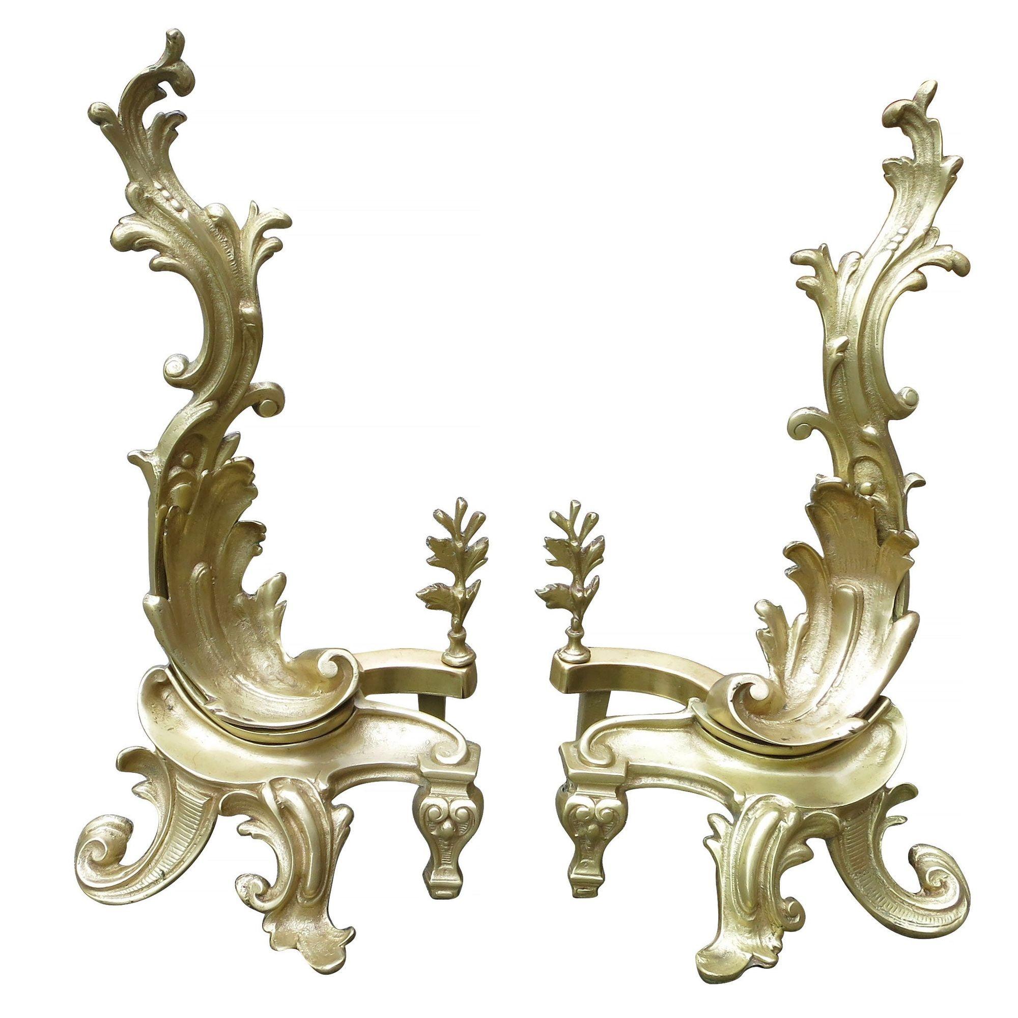 Late Victorian brass andirons featuring two Rococo, late-Baroque-style designs in Classic asymmetrical patterns. This is for a pair of antique Rococo-style, solid brass andirons / chenets / firedogs featuring acanthus leaves with curves that flow in