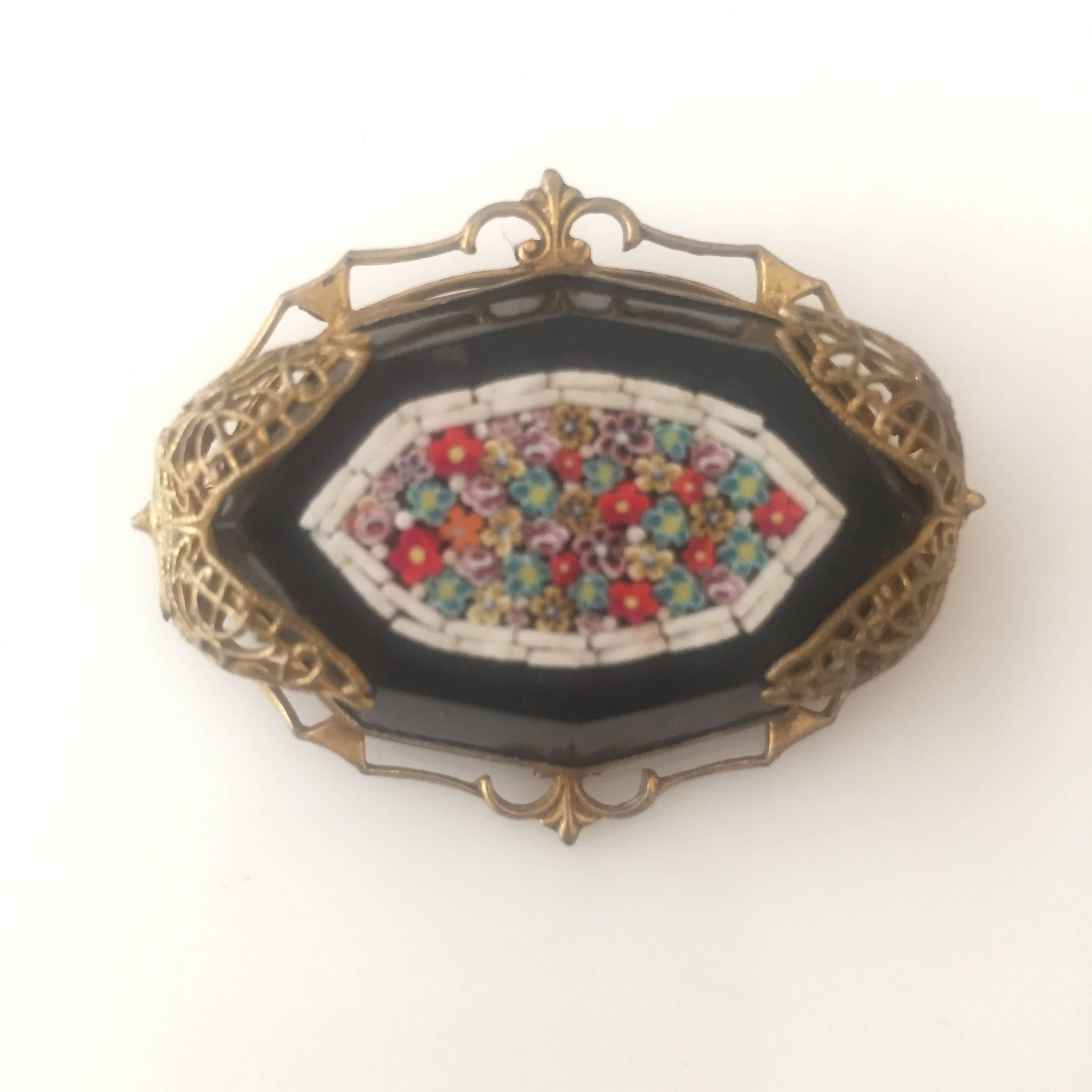 Late Victorian Murano glass mosaic on a black jet stone set in a golden filigree backing.

Measures: 1 3/4