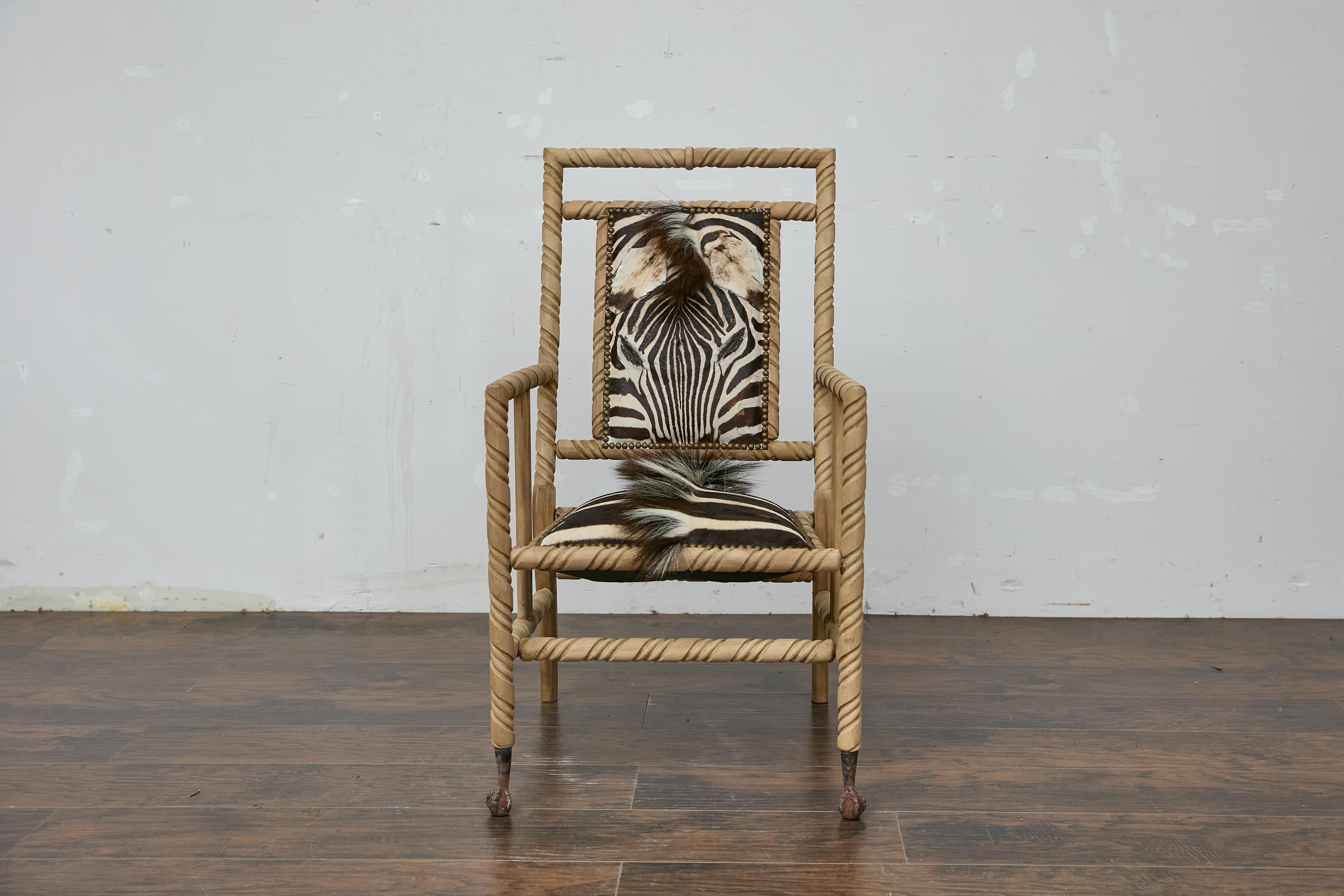Poltrona tardo-vittoriana in rovere con imbottitura in pelle di zebra e piedi a sfera. Questa poltrona tardo-vittoriana in rovere a torsione d'orzo emana un'eccezionale miscela di artigianato tradizionale e fascino esotico, affascinando con la sua