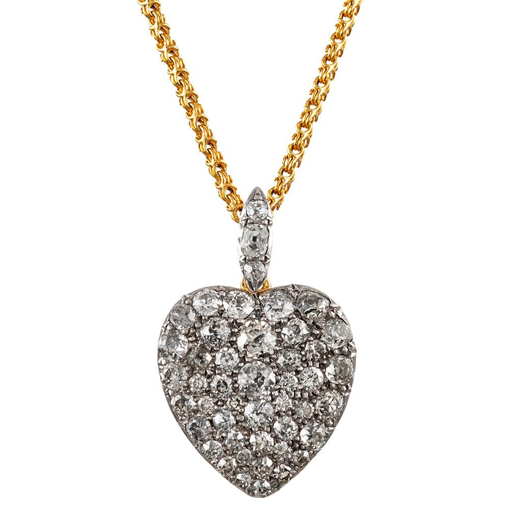 Adorned with approximately 4 carats of old mine brilliant diamonds, the pendant measures 1 ¼ inches long including the bale and 7/8 of an inch wide. It is made of 18 karat yellow gold and platinum, suspended from a 10 inch golden chain. Bestow upon