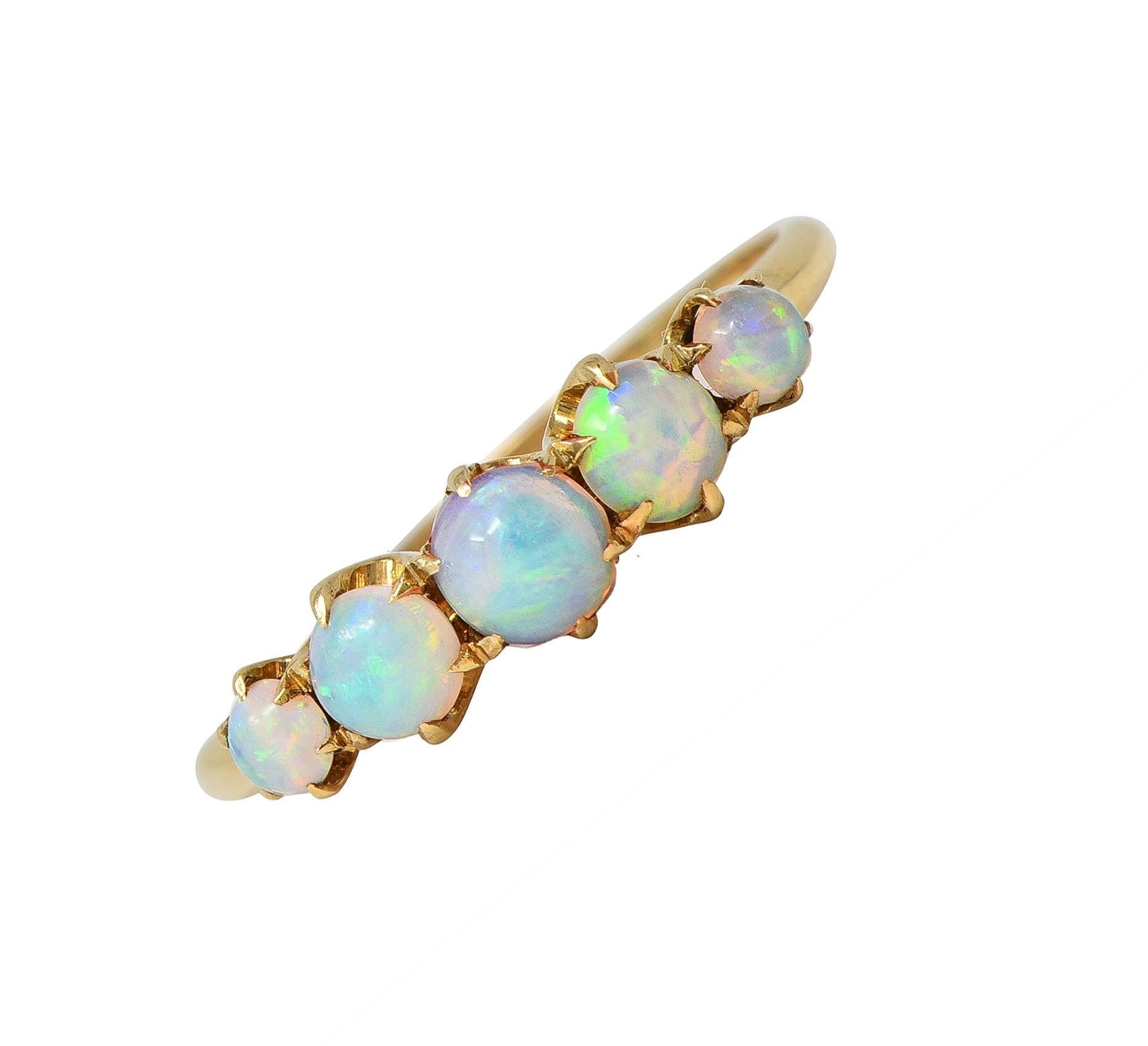 Cinq cabochons d'opale de forme ronde sont sertis d'est en ouest sur des griffes en forme de talon.
Gradués et d'une taille allant de 3,0 à 4,5 mm ronds 
Blanc translucide avec jeu de couleurs spectrales
Estampillé pour l'or 14 carats
Avec la marque