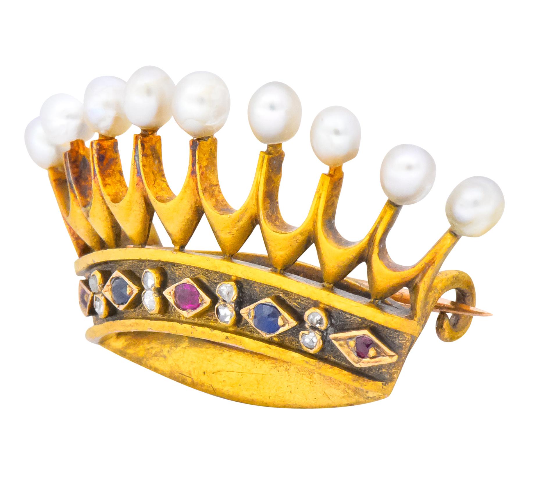 Brooch designed as crown with each tine topped with a natural freshwater pearl, cream in body color with good luster

Band decorated with Swiss cut rubies and sapphires set in a small navette mounting, accented by bezel set rose cut diamonds in