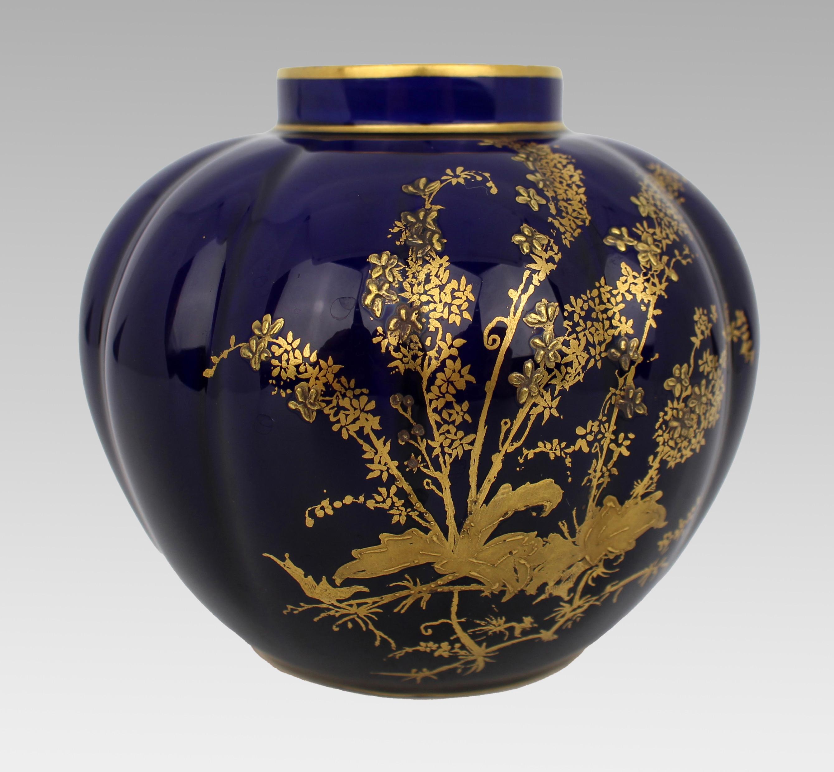 Vase bleu cobalt et doré Royal Crown Derby de la fin de l'époque victorienne
Daté de 1900

Vase en porcelaine Royal Crown Derby de la fin de l'époque victorienne, de forme arrondie et nervurée. Riche fond bleu cobalt avec un décor floral et feuillu