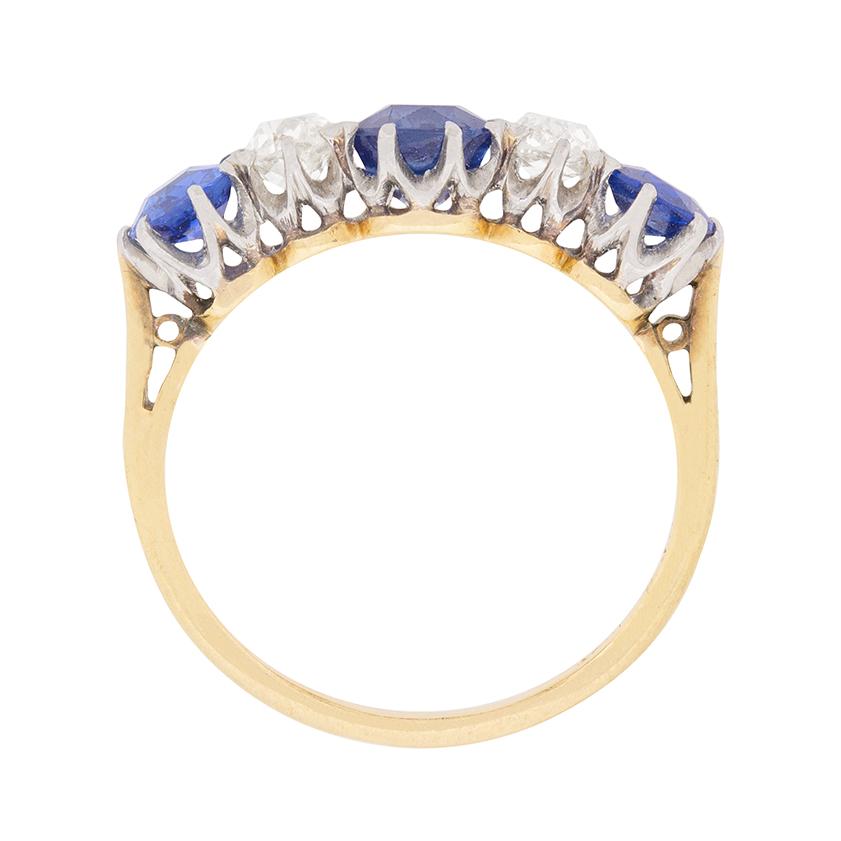 A oval-shaped trio of sapphires in a brilliant shade of blue alternates with a glittering pair of 0.25ct old cut diamonds to comprise this early twentieth century rendition of the traditional five stone ring.

These antique sapphires and diamonds