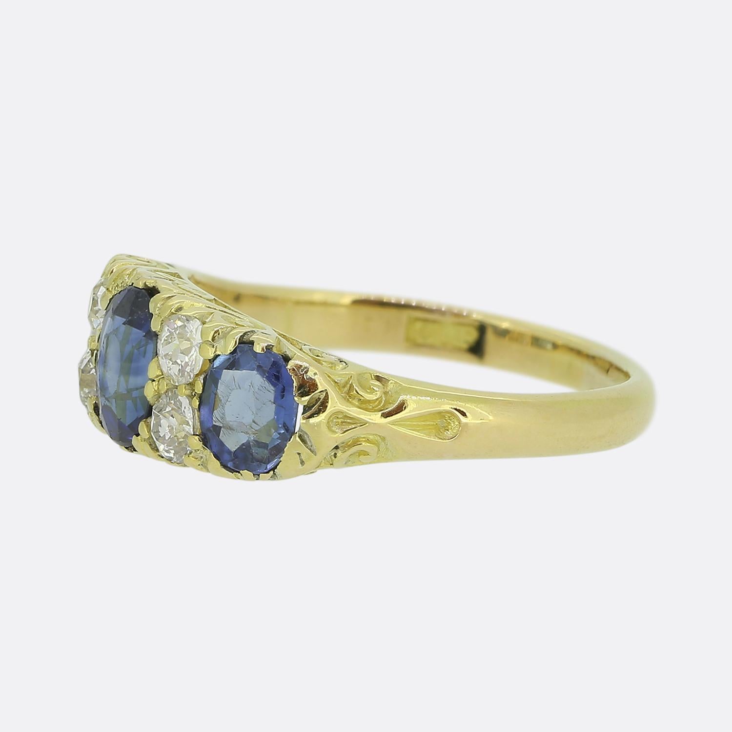 Here we have a classically styled three-stone ring taken from the Victorian period. The ring showcases a trio of blue sapphires, elegantly claw set atop an 18ct yellow gold mount. Flanking the central sapphire is a duo of round faceted old mine cut