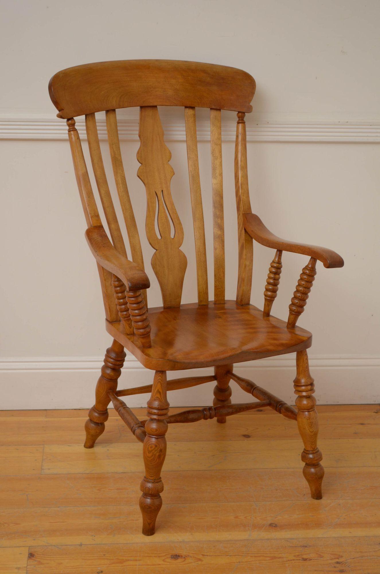 Sn084 Late Victorian Windsor chair in satinbirch, having shape top rail with carved centre support flanked by four slats, generous seat and open arms on bobbing uprights, all standing on four turned and ringed legs united by four stretchers. This
