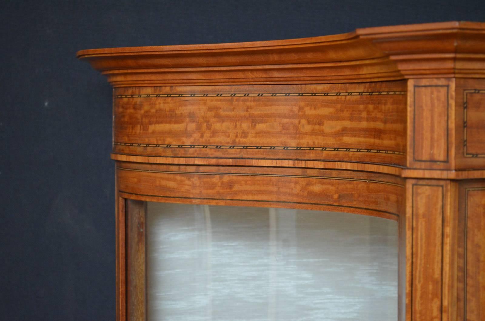 Sn4352, superb quality and very stylish late Victorian display cabinet / vitrine of serpentine outline, having moulded cornice above string inlaid frieze and glazed door enclosing newly lined interior with two shelves, all flanked by serpentine