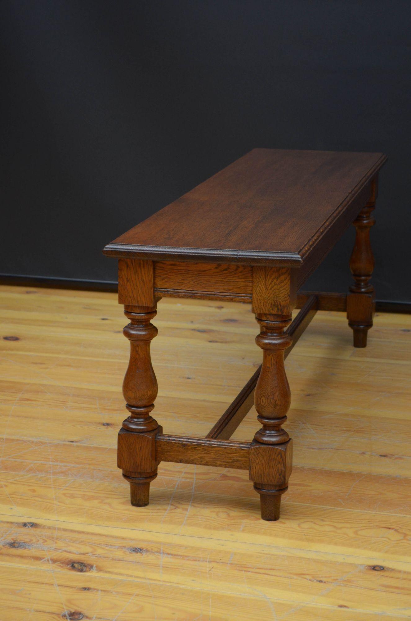 Sn5484 Late Victorian solid oak hall seat, having long top with moulded edge above reeded frieze, all standing on four turned and shaped legs united by stretchers. This antique hall bench has been sympathetically restored and is in home ready