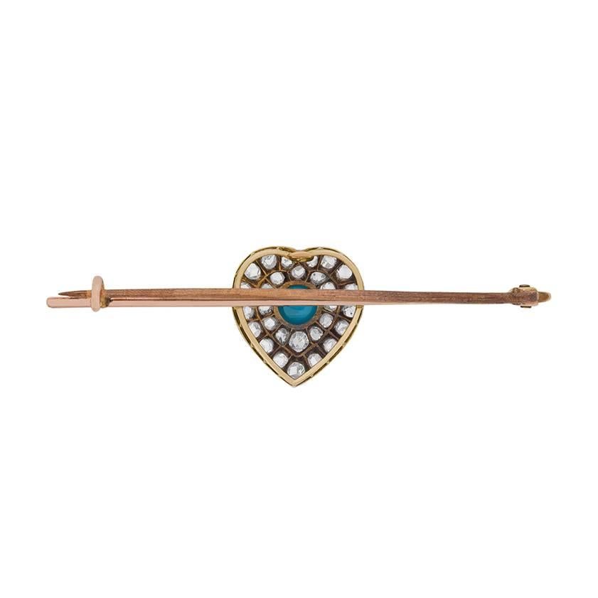 An antique turquoise and diamond brooch dating from around the turn of the twentieth century and featuring a romantic heart motif.

Set in platinum-accented 18 carat yellow gold, this late Victorian era brooch centres a cabochon turquoise amid a