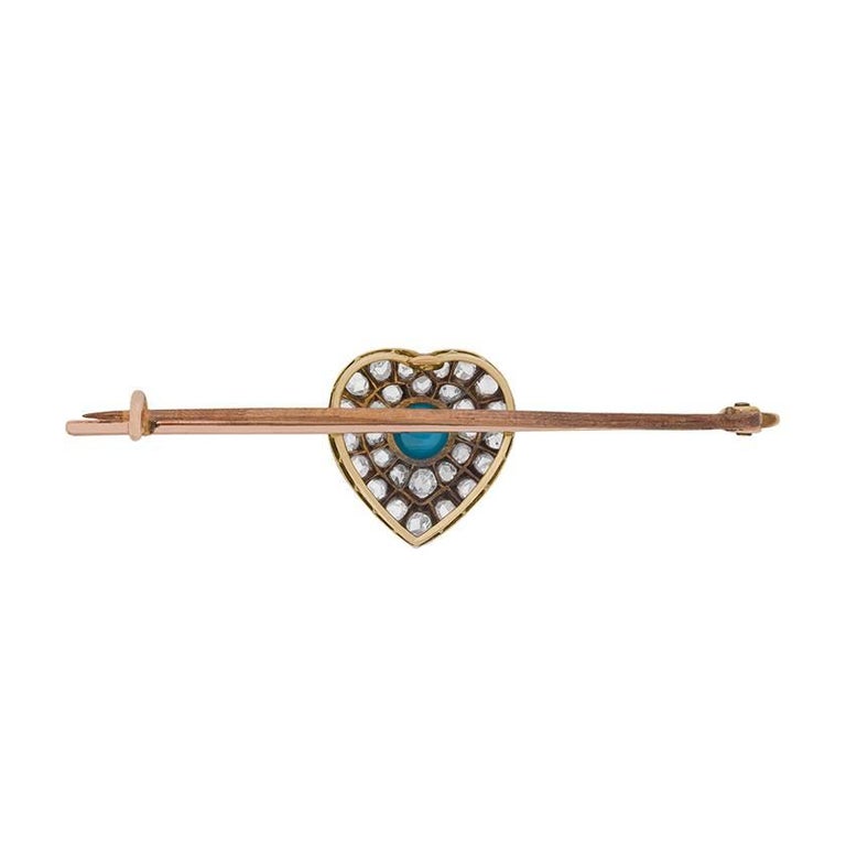 An antique turquoise and diamond brooch dating from around the turn of the twentieth century and featuring a romantic heart motif.

Set in platinum-accented 18 carat yellow gold, this late Victorian era brooch centres a cabochon turquoise amid a
